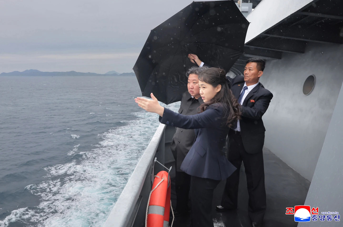 Kim Jong Un, left, and his daughter observe the sea trials of a ship.