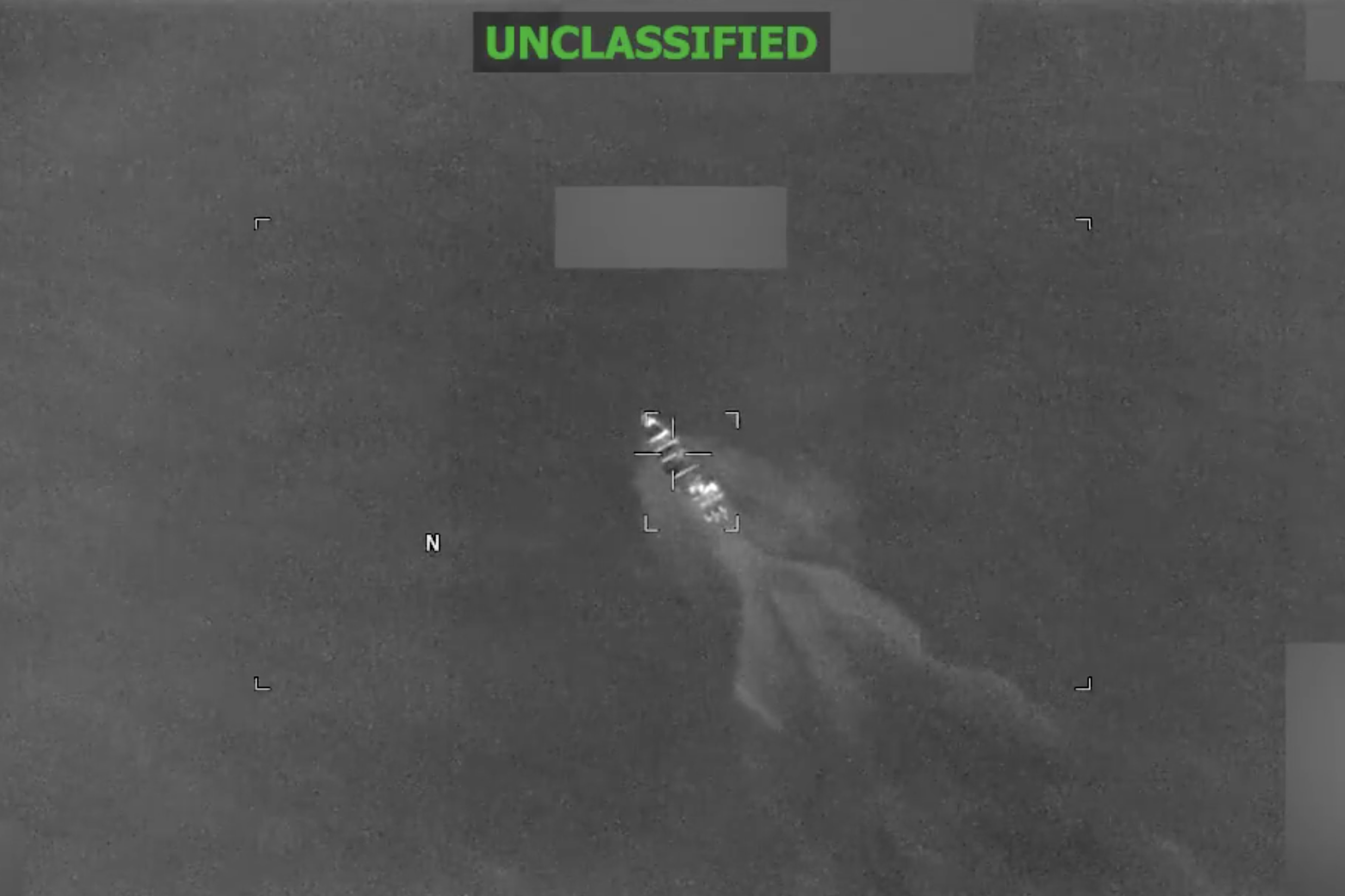 Grainy black-and-white video footage of boat attack.