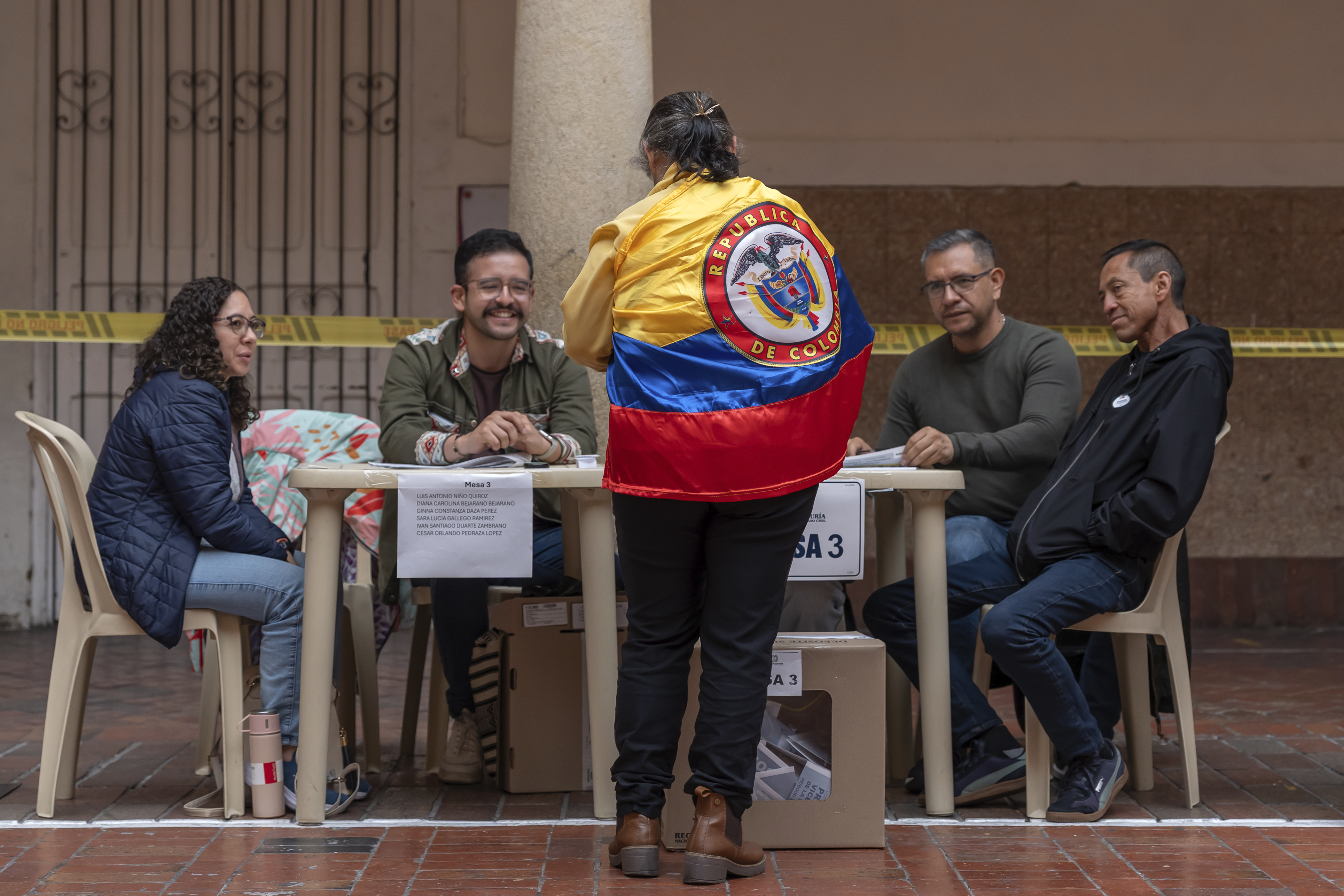 BOGOTA, COLOMBIA - MAY 31: A woman wearing a Colombian flag registers to cast her vote during the presidential election on May 31, 2026 in Bogota, Colombia. Polls point to Ivan Cepeda, candidate for the Pacto Historico party, Paloma Valencia, candidate for the Centro Democratico party, and Abelardo de la Espriella, candidate for the Salvación Nacional party, as the main contenders for this year's election in Colombia (Photo by Leonardo Castañeda/Getty Images/Getty Images)