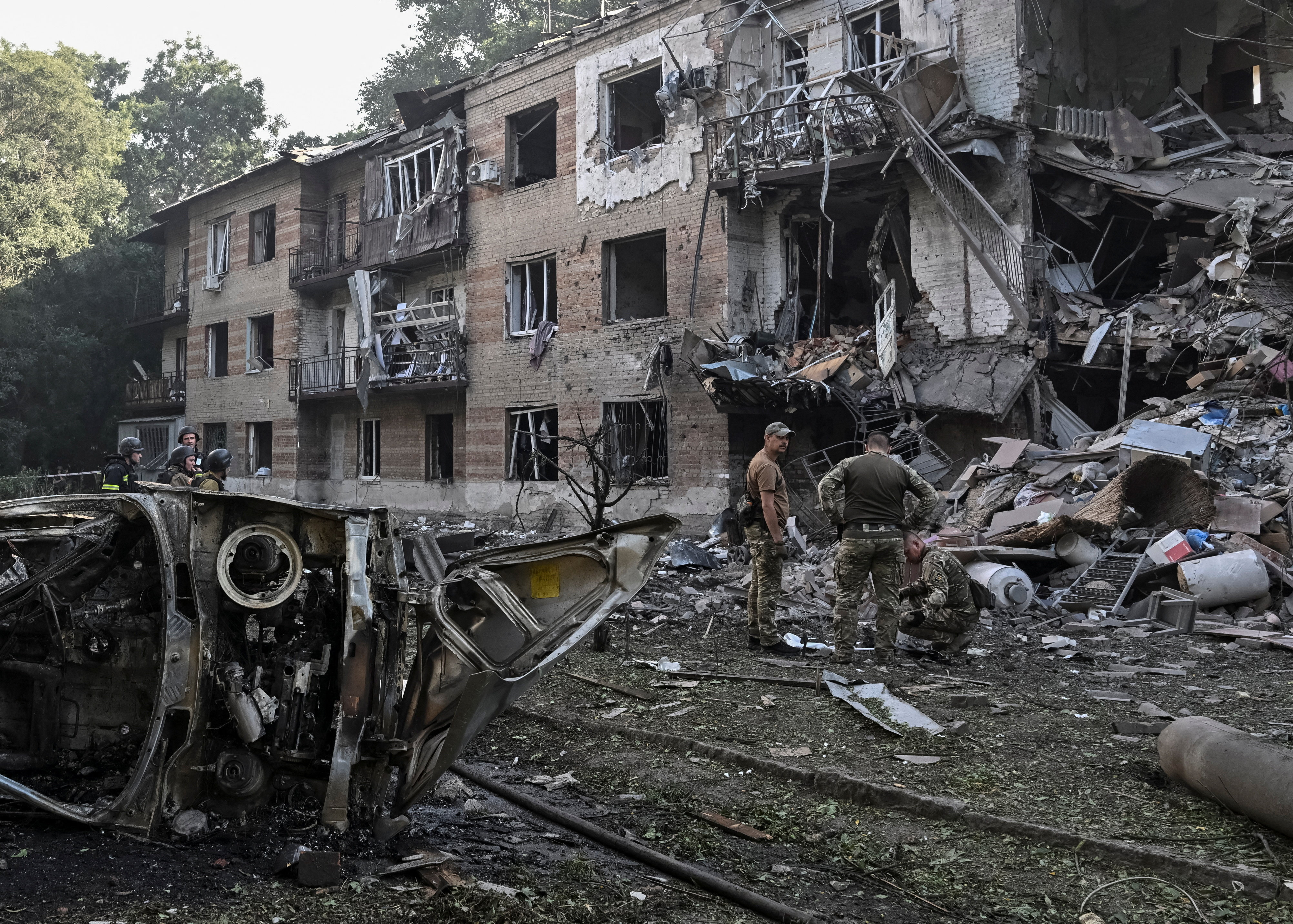 Rescuers and police officers work at the site of an apartment building hit by a Russian air attack in Zaporizhzhia, Ukraine