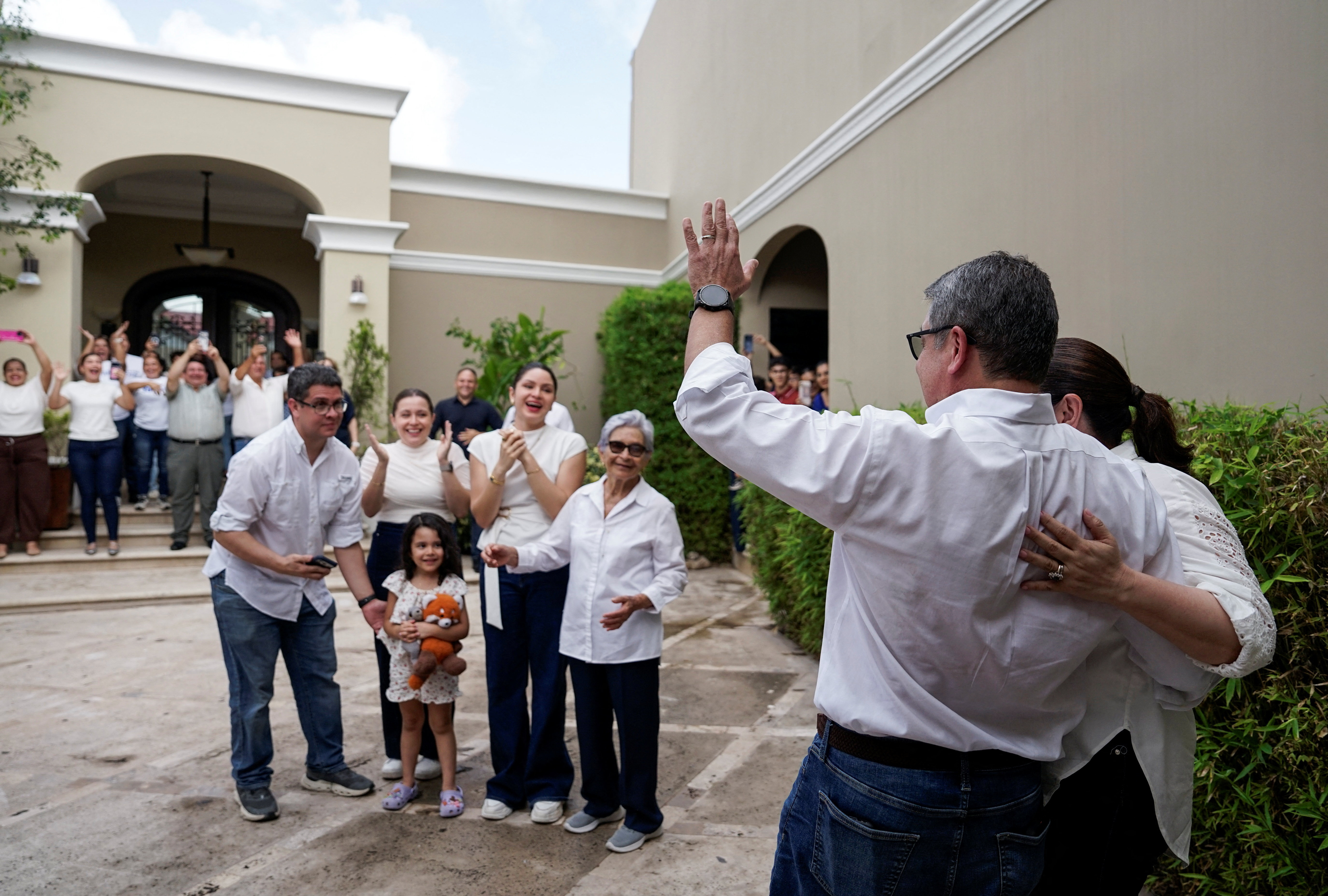 Former Honduran President Juan Orlando Hernandez is greeted by family and friends after arriving at his home in Tegucigalpa following his return to Honduras on July 26, 2026