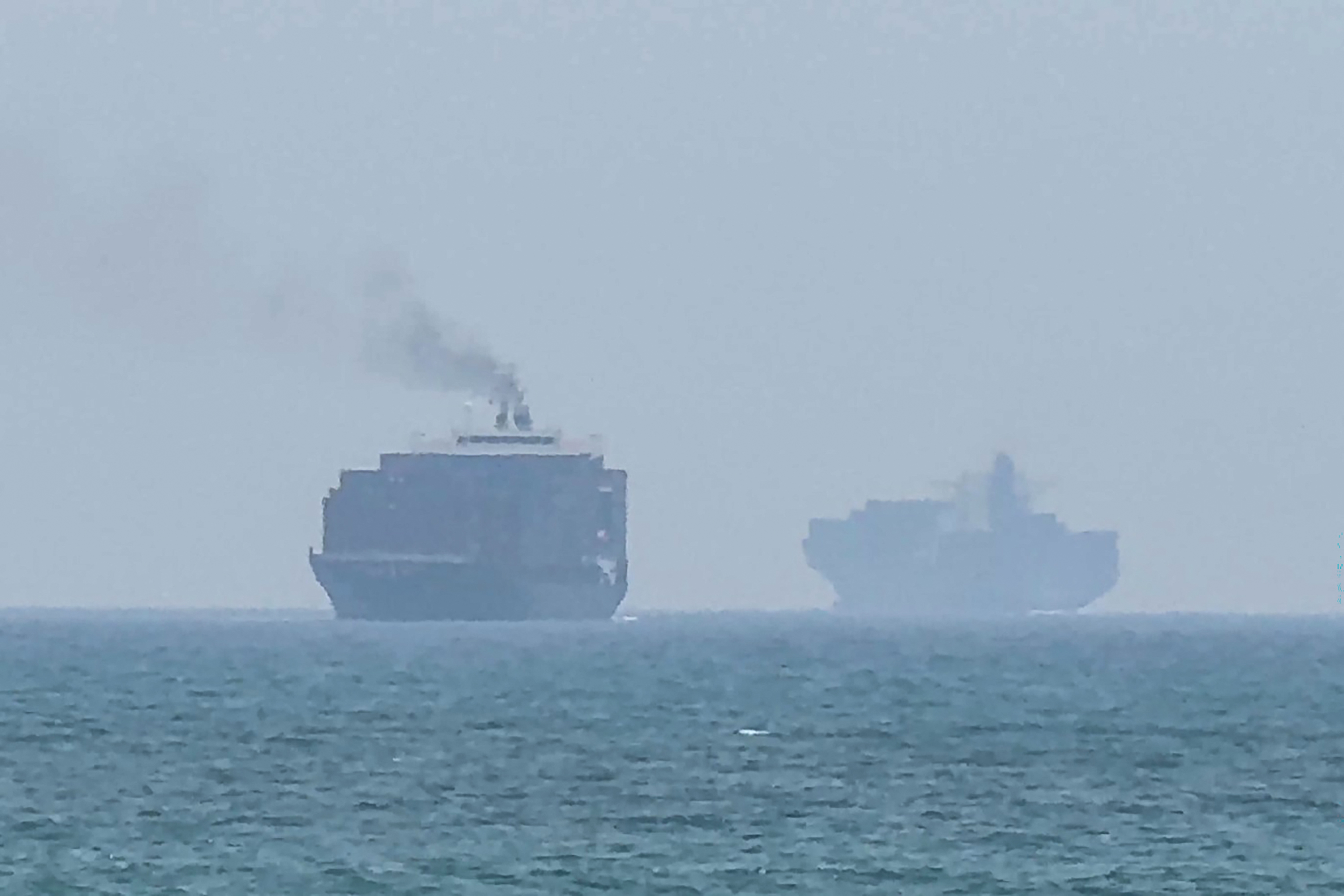 TOPSHOT - This frame grab taken from AFPTV video footage on July 12, 2026 shows cargo ships anchoring near the Strait of Hormuz off the eastern coast of the United Arab Emirates at Khor Fakkan.