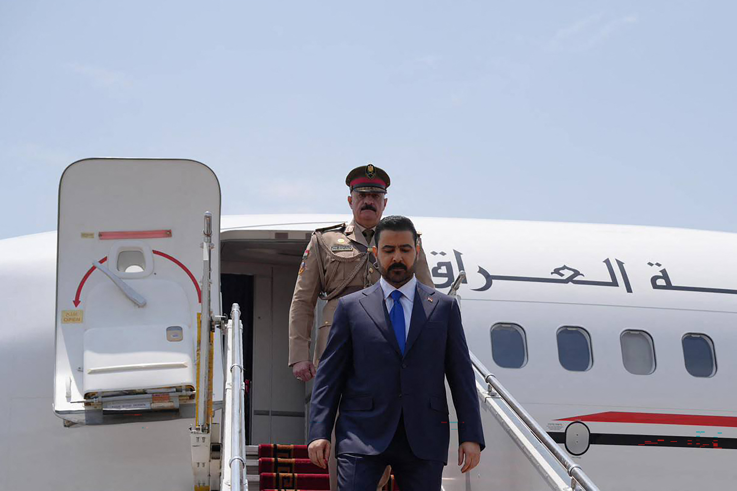This handout picture taken and released on July 23, 2026 by the Iraqi Prime Minister's Office shows Iraq's Prime Minister Ali al-Zaidi (R) disembarking from his plane upon landing in Tehran.