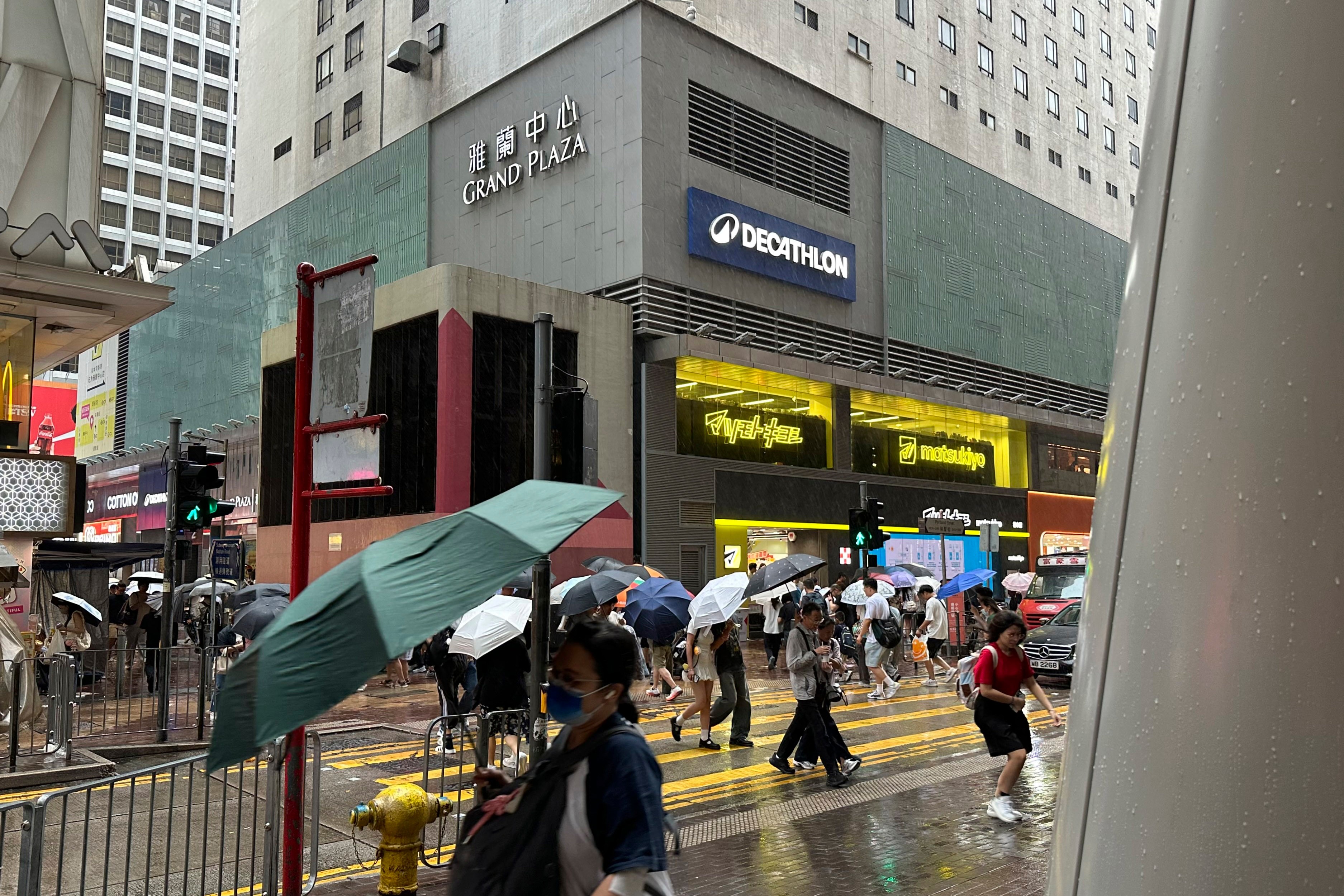 Passersby walk in Hong Kong's Mong Kok district under heavy rain and wind ahead of Typhoon Noul on Saturday, July 25, 2026. (AP Photo/Chan Ho-him)