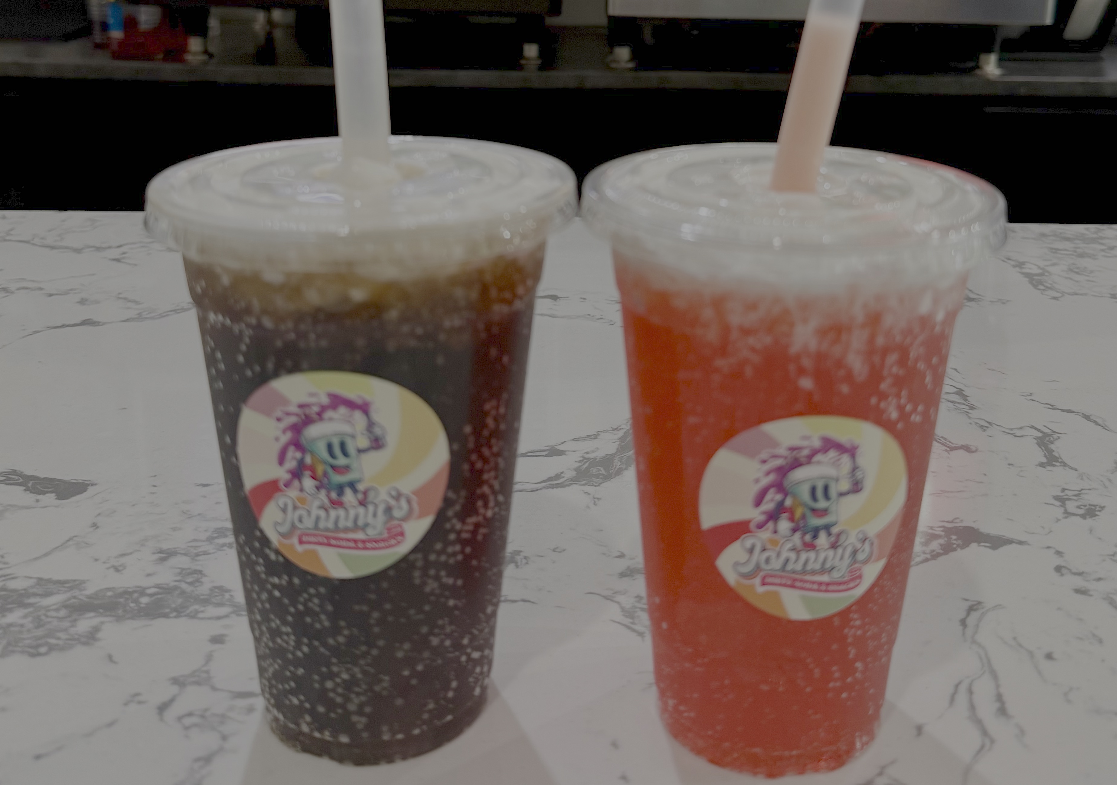 Chicago's first standalone dirty soda shop, Johnny's, opened in early 2026. Pictured are two of their most popular options: the My Leige (Dr Pepper, black cherry, vanilla and cold foam), left, and the Infinite Aura (Mountain Dew Code Red, cherry and cold foam), right [Michelle Bruton/Al Jazeera]