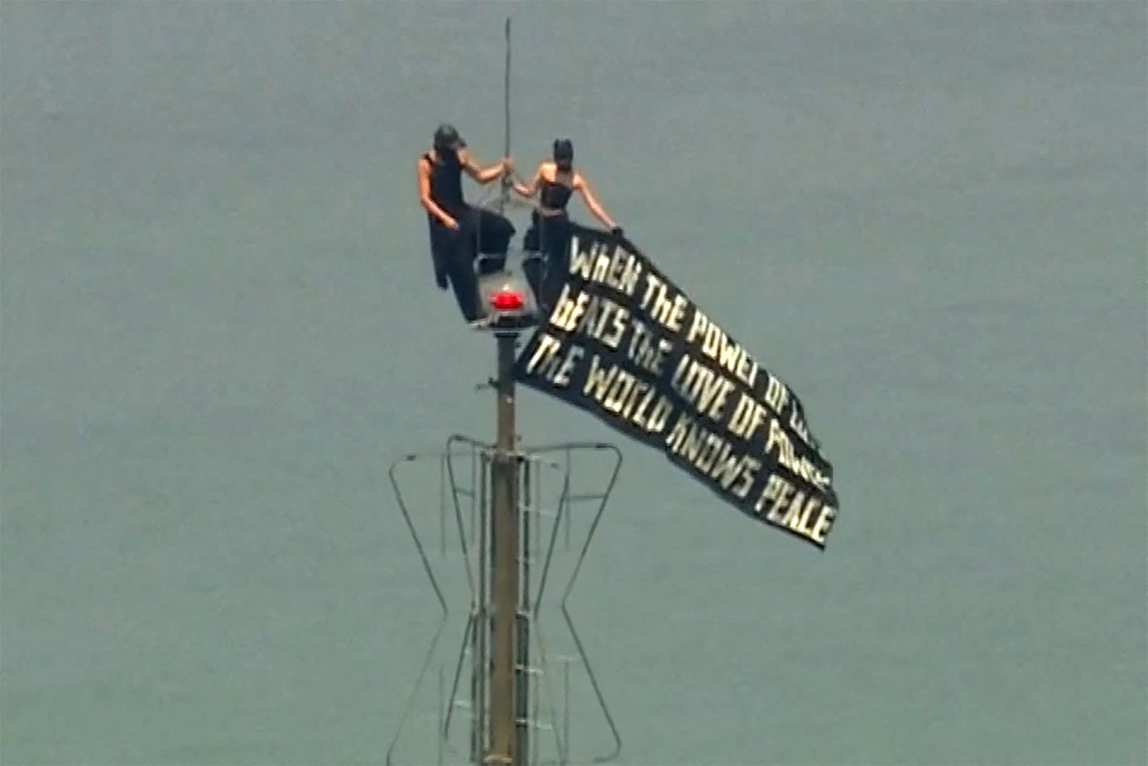 Two people display a banner atop the Empire State Building in the Manhattan borough of New York, U.S., July 1, 2026, in a still image from video. [ABC affiliate WABC/Reuters}