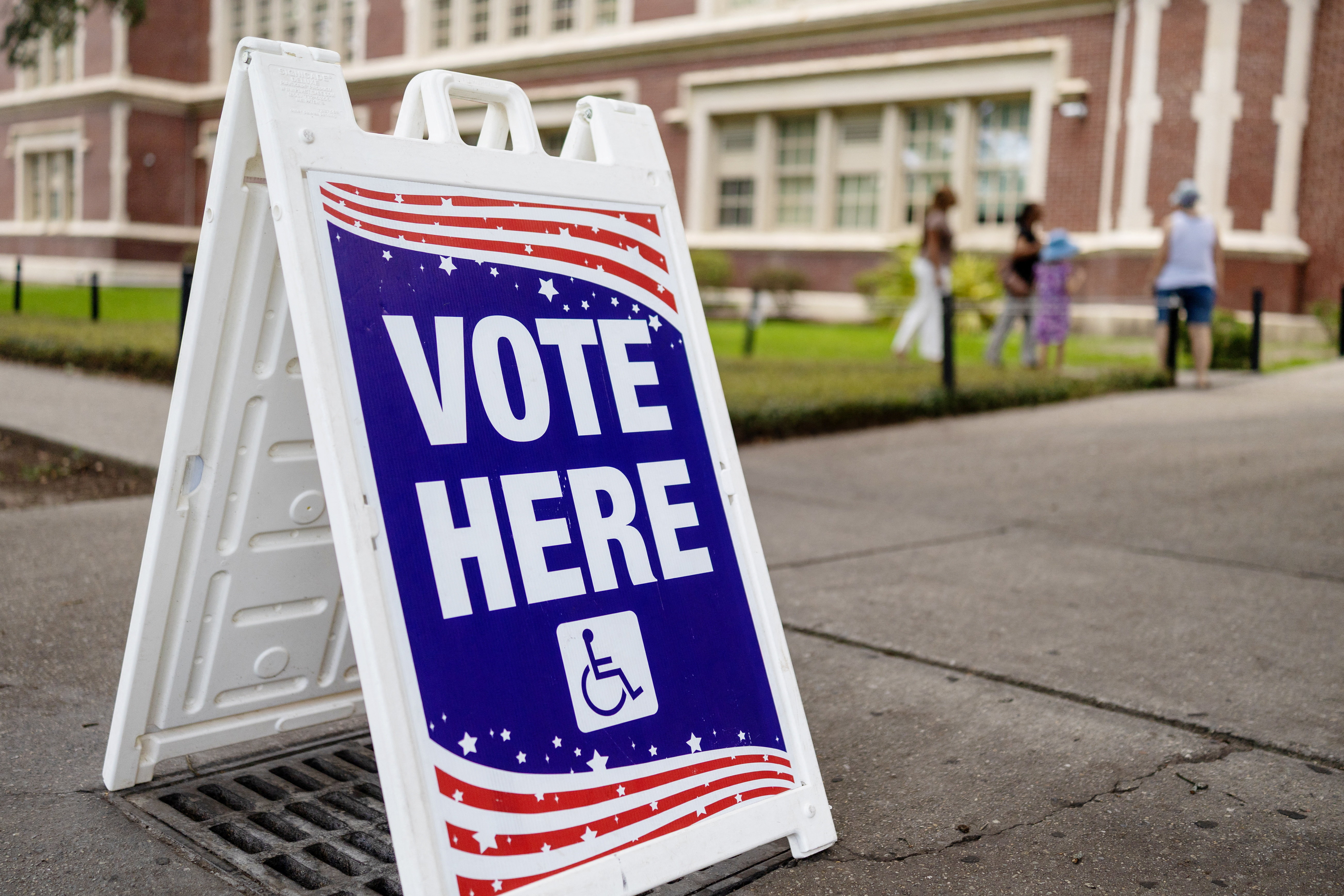 People walk outside Warren Easton High School during the Senate primary runoff election in New Orleans, Louisiana, U.S., June 27, 2026. REUTERS/Kathleen Flynn