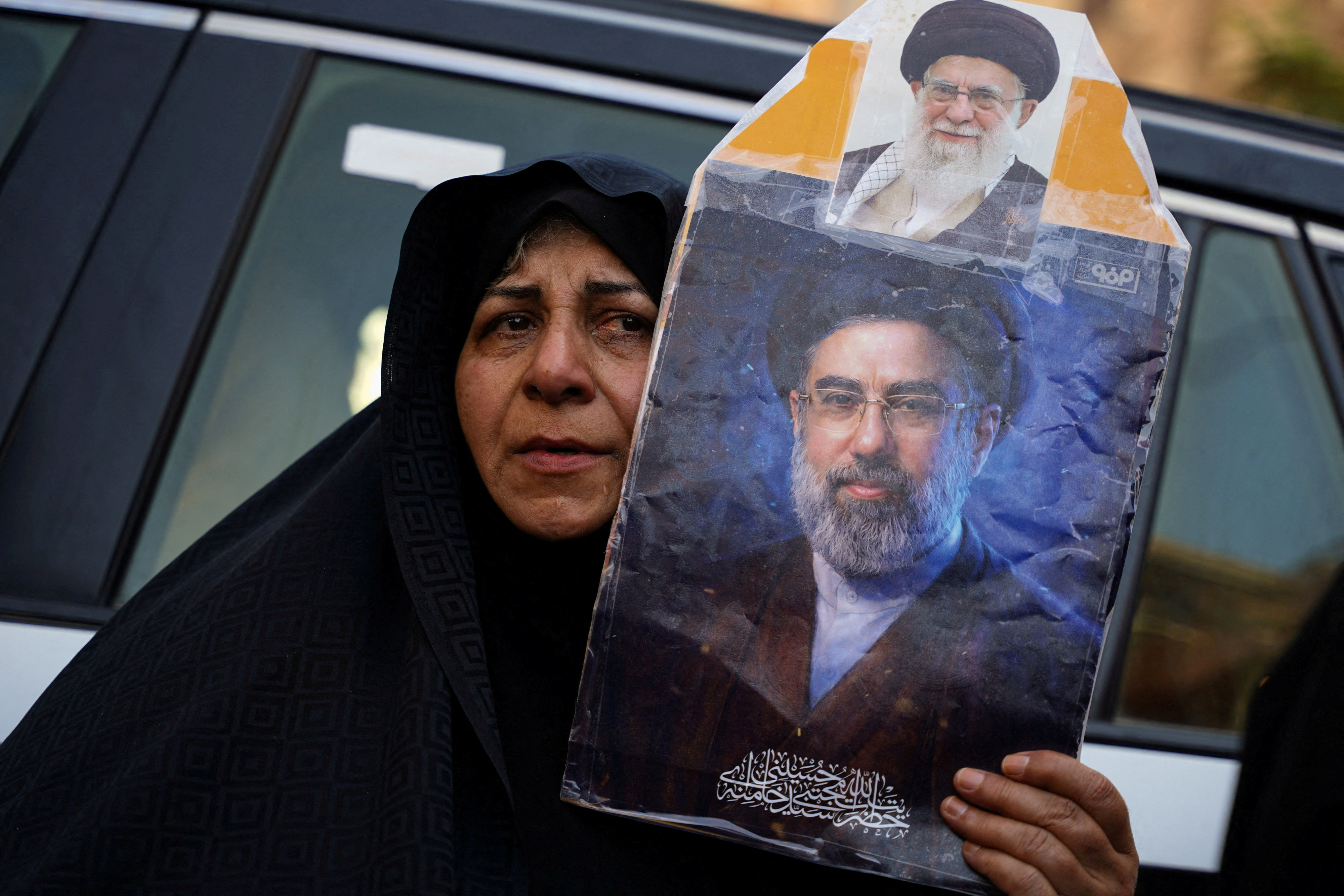 FILE PHOTO: A woman holds a portrait of Iran's Supreme Leader Mojtaba Khamenei and Iran’s late Supreme Leader Ayatollah Ali Khamenei, who was killed on February 28 during Israeli and U.S. airstrikes on Iran, as mourners gather during funeral ceremonies in Karbala, Iraq, July 8, 2026. REUTERS/Teba Sadiq/File Photo