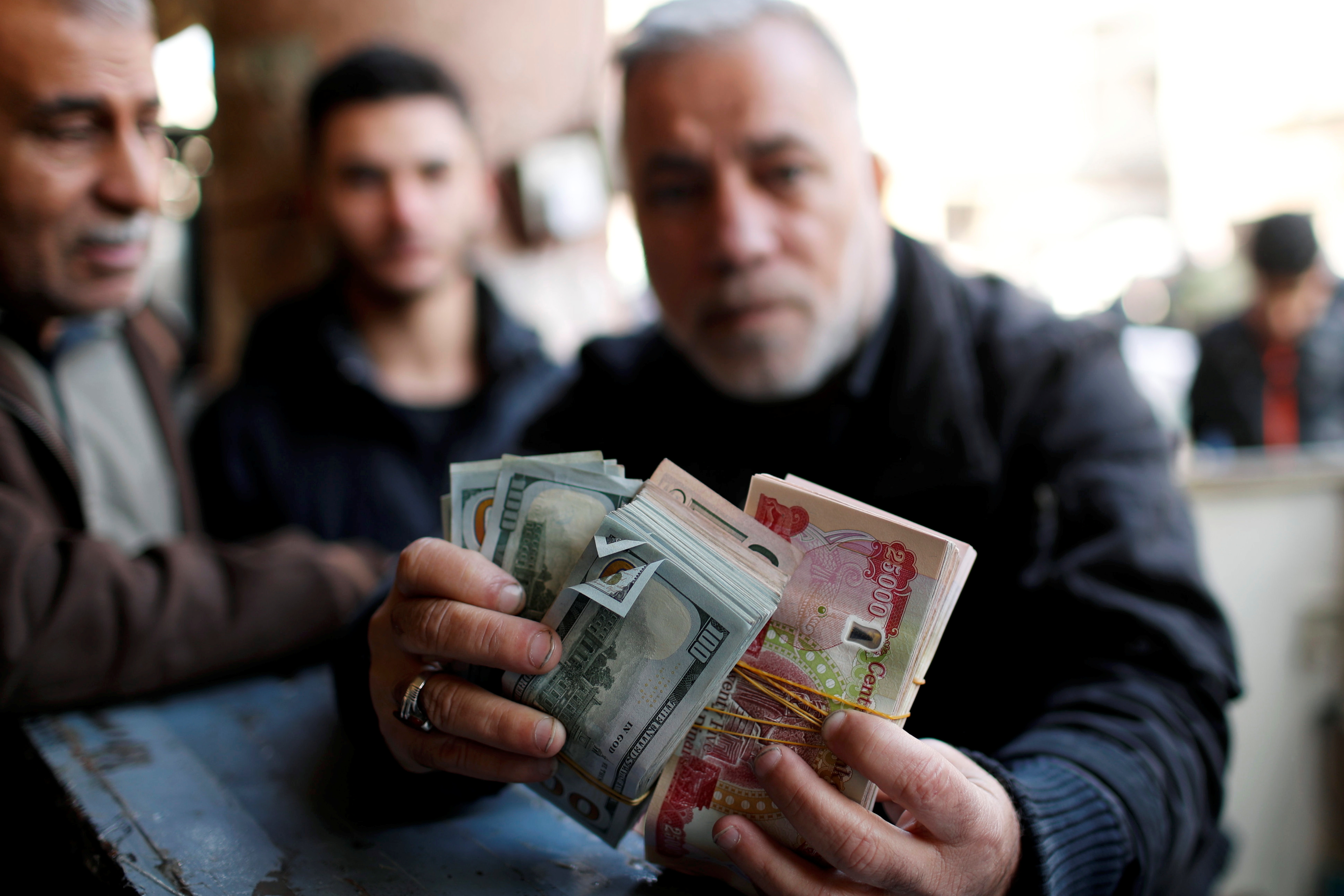 A man holds money as he poses for a picture.