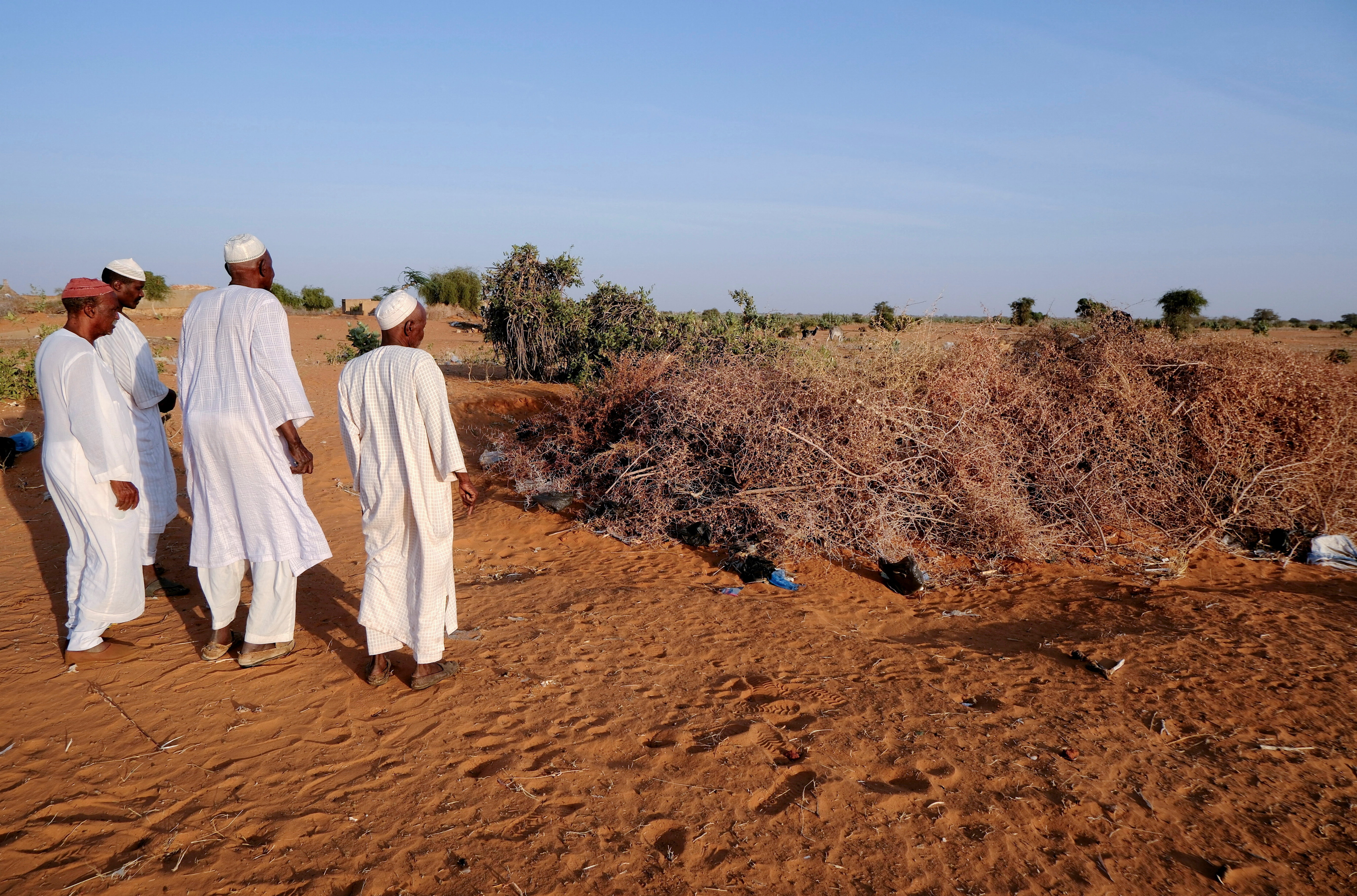 Men from Al-Luwaib village in North Kordofan stand at a burial site, where victims of a drone strike were buried, in El Obeid, North Kordofan State, Sudan, January 14, 2026.