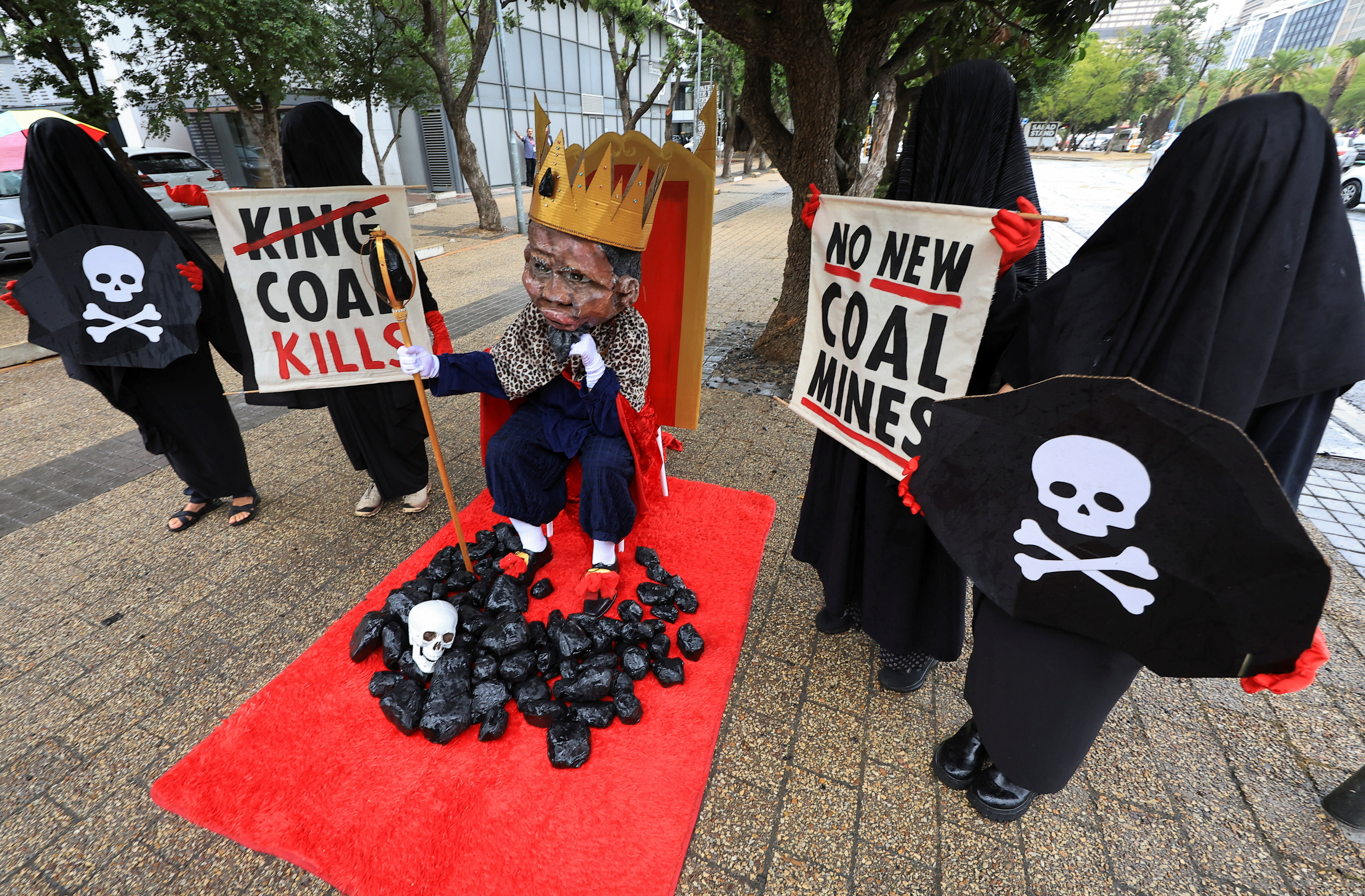 Members of Extinction Rebellion stage a protest with a figure depicting South African Minister of Mineral and Petroleum Resources Gwede Mantashe outside the Investing in African Mining Indaba conference in Cape Town, South Africa, on February 9, 2026