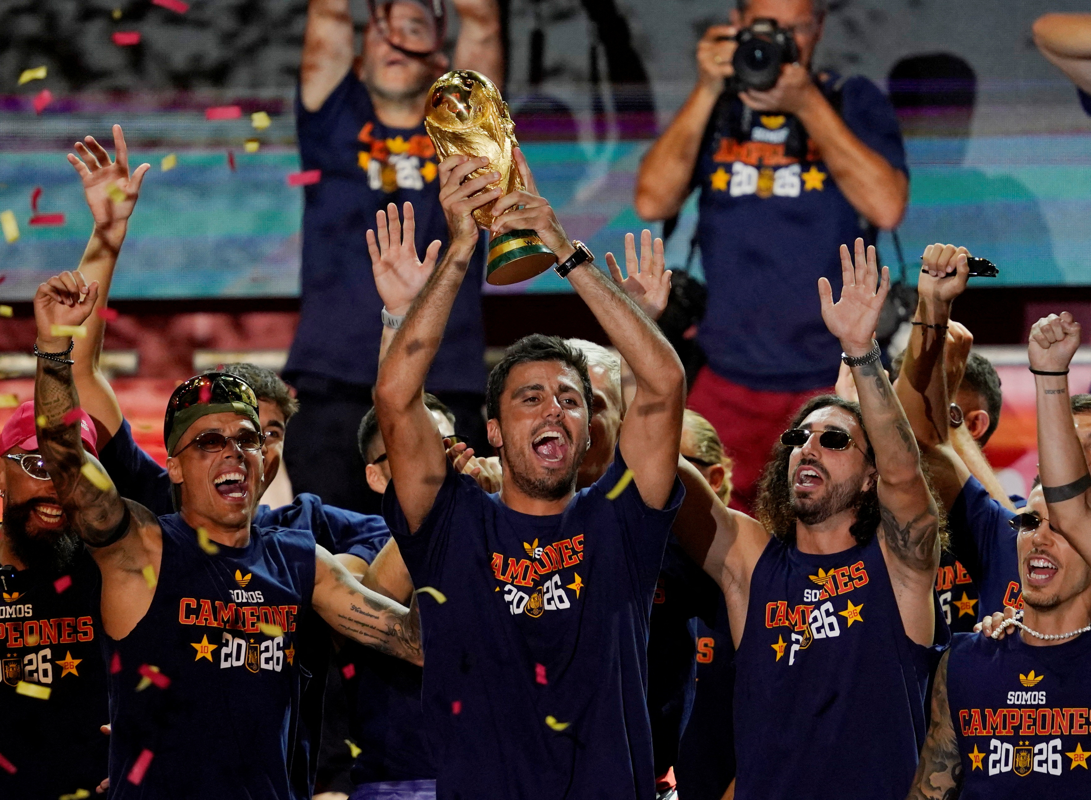 Spain's Rodri celebrates with the World Cup trophy and teammates on stage at Cibeles Square in Madrid after the victory parade as fans gather to celebrate winning the World Cup