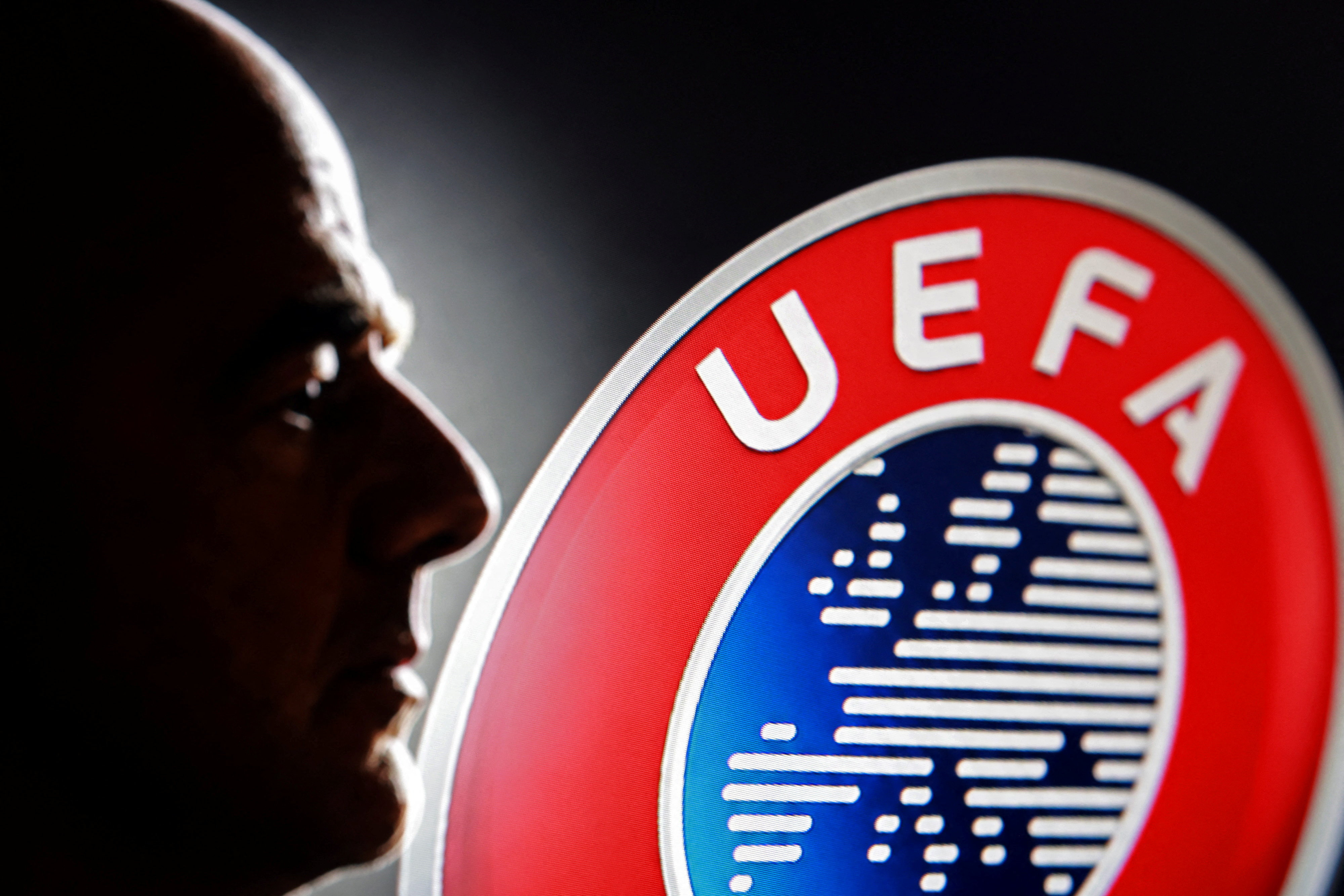 A silhouette depicting FIFA President Gianni Infantino is seen next to a UEFA logo in this illustration