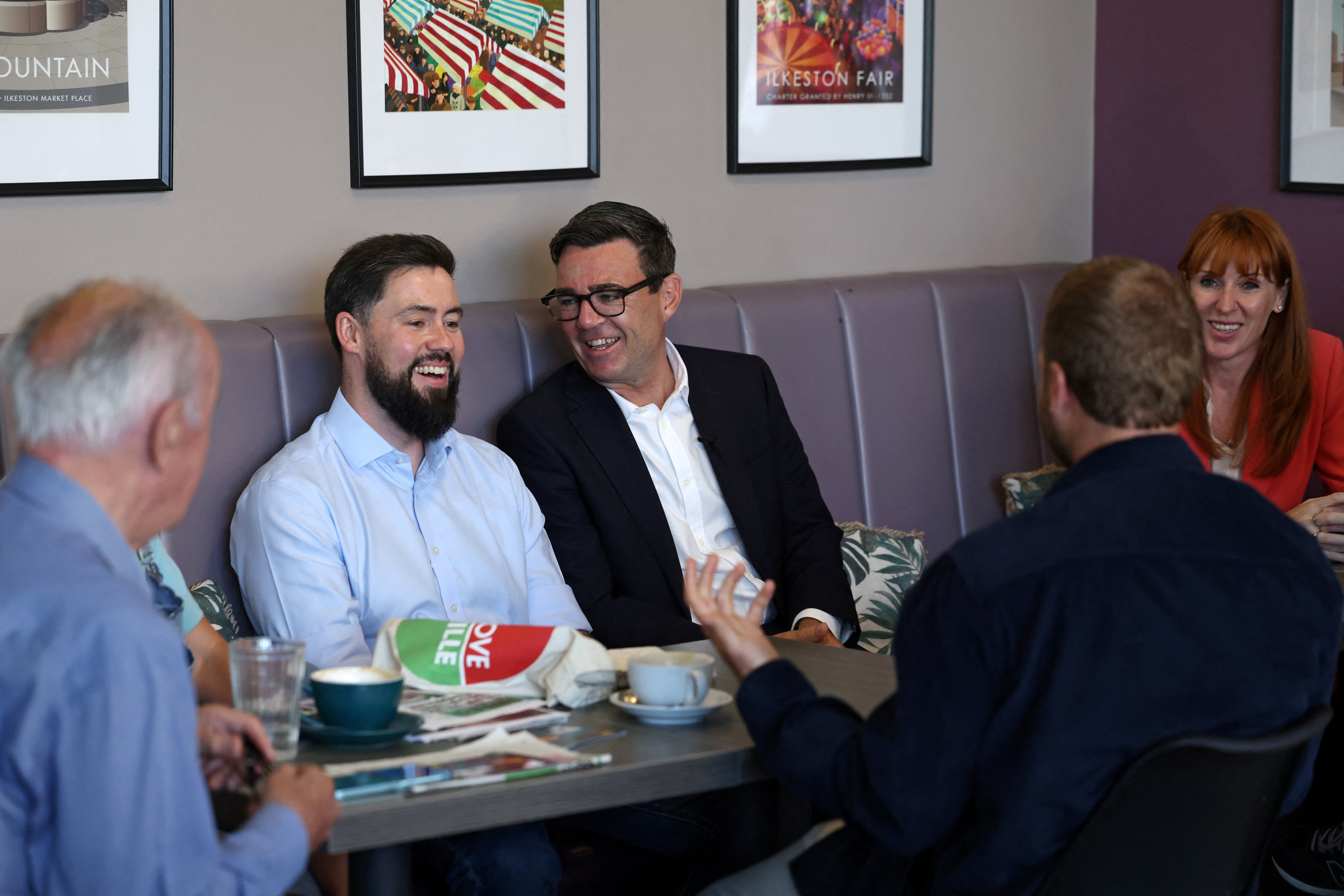 Britain's Prime Minister Andy Burnham, Labour MP for Erewash Adam Thompson and Britain's Housing Secretary Angela Rayner meet with local business owners and guests at The Hub cafe during a visit to Ilkeston, Derbyshire, Britain, August 11, 2026. TOBY SHEPHEARD/Pool via REUTERS