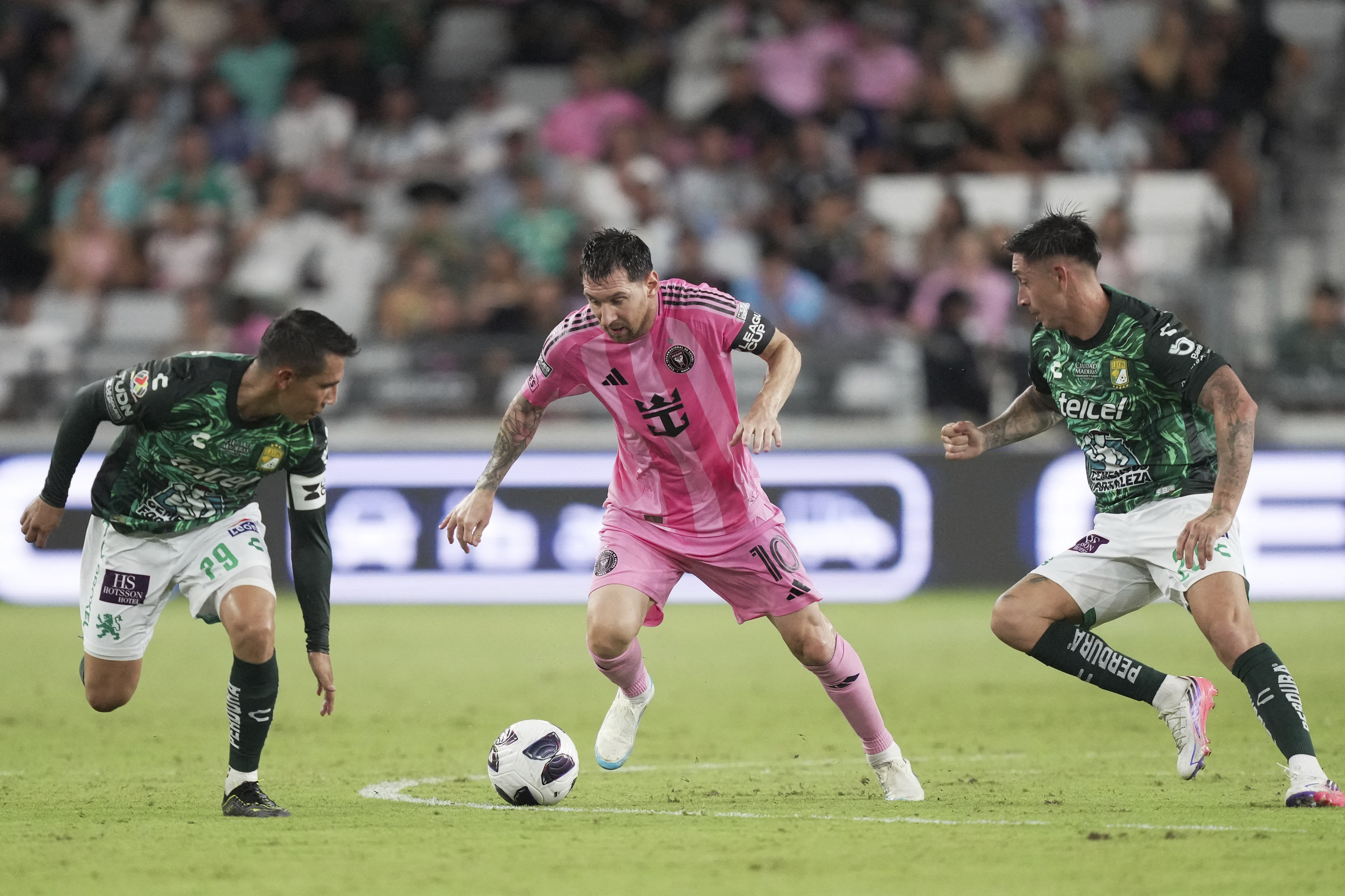 Inter Miami’s Leo Messi, centre, is pressed by León’s Jose Alvarad, left, and James Rodriguez, right, during the Leagues Cup match