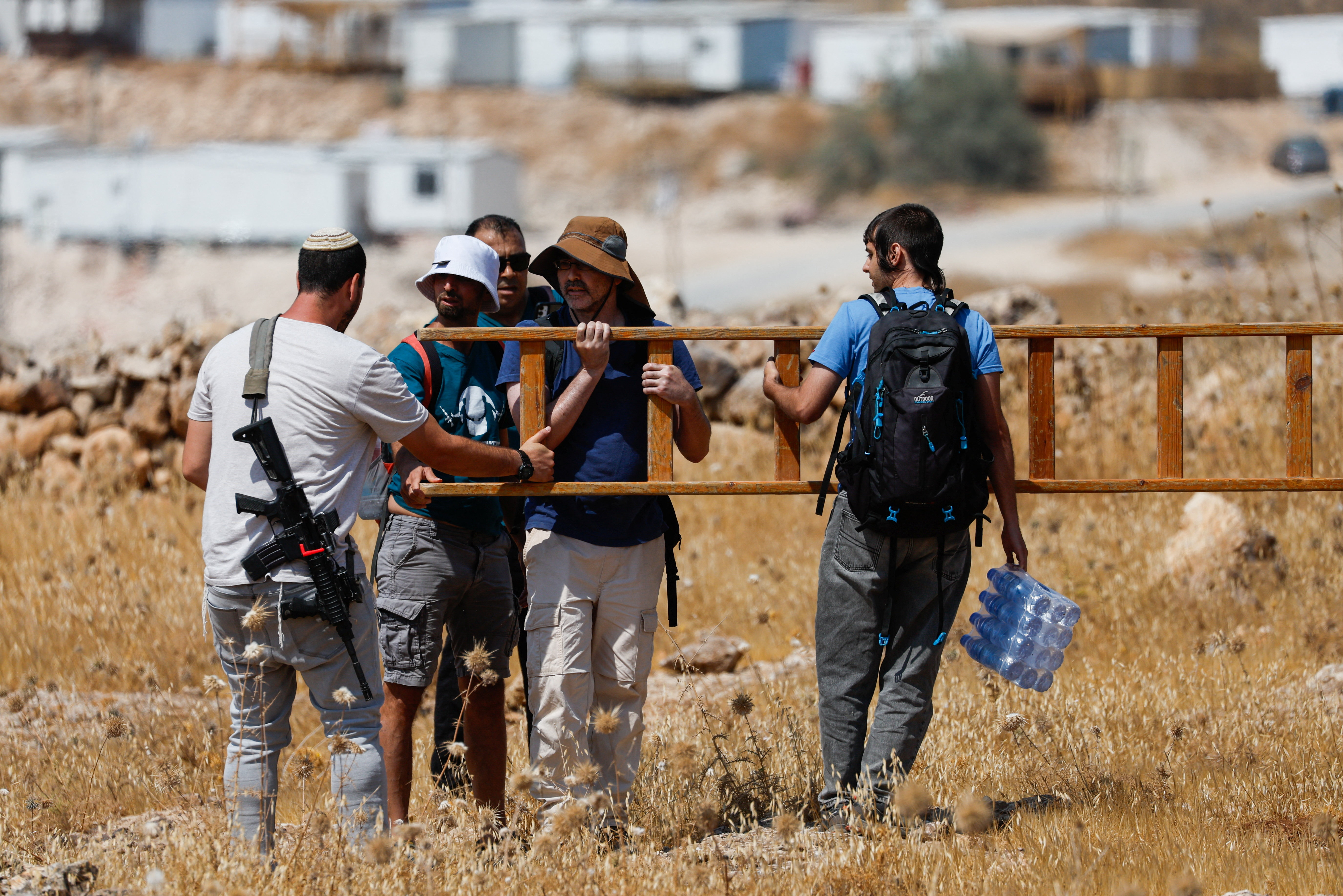 Israeli settlers confront Palestinian and Israeli activists accompanying Palestinian landowners in their property, which is threatened with confiscation by Israeli settlers, in Beit Sahour in the Israeli-occupied West Bank August 14, 2026. REUTERS/Mussa Qawasma