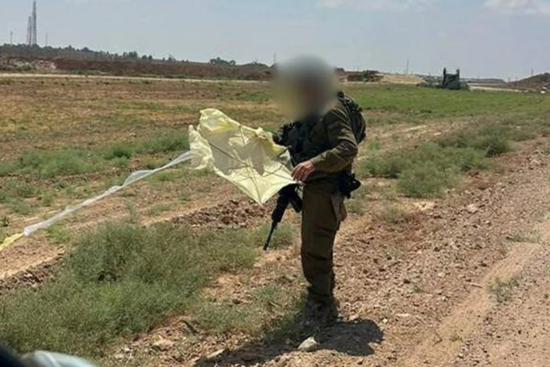 An Israeli soldier inspects a kite in the Gaza envelope, allegedly launched from the Strip [Al Jazeera]