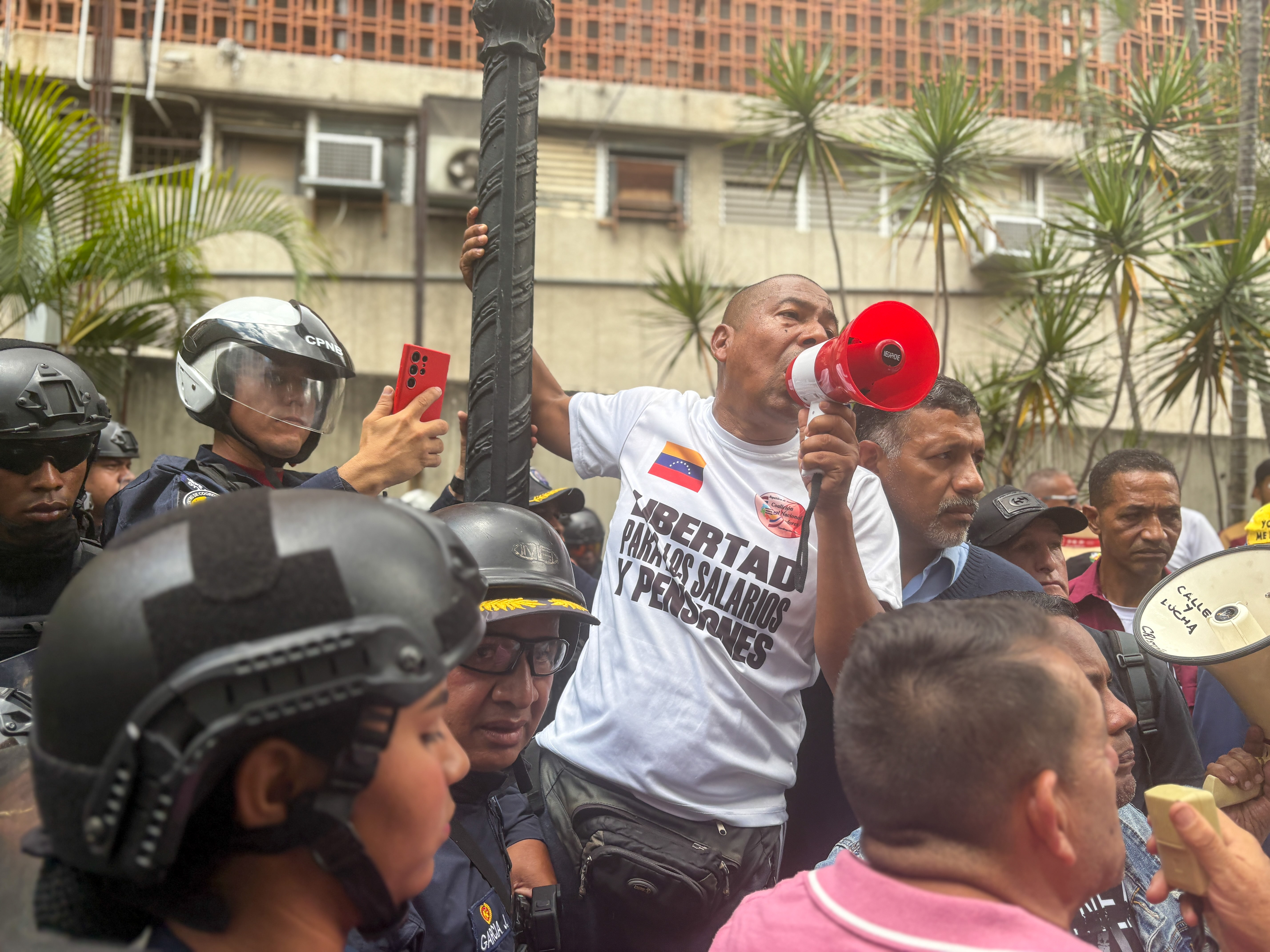 Protesters outside the talks in Caracas call for better wages and pensions [Catherine Ellis/Al Jazeera]