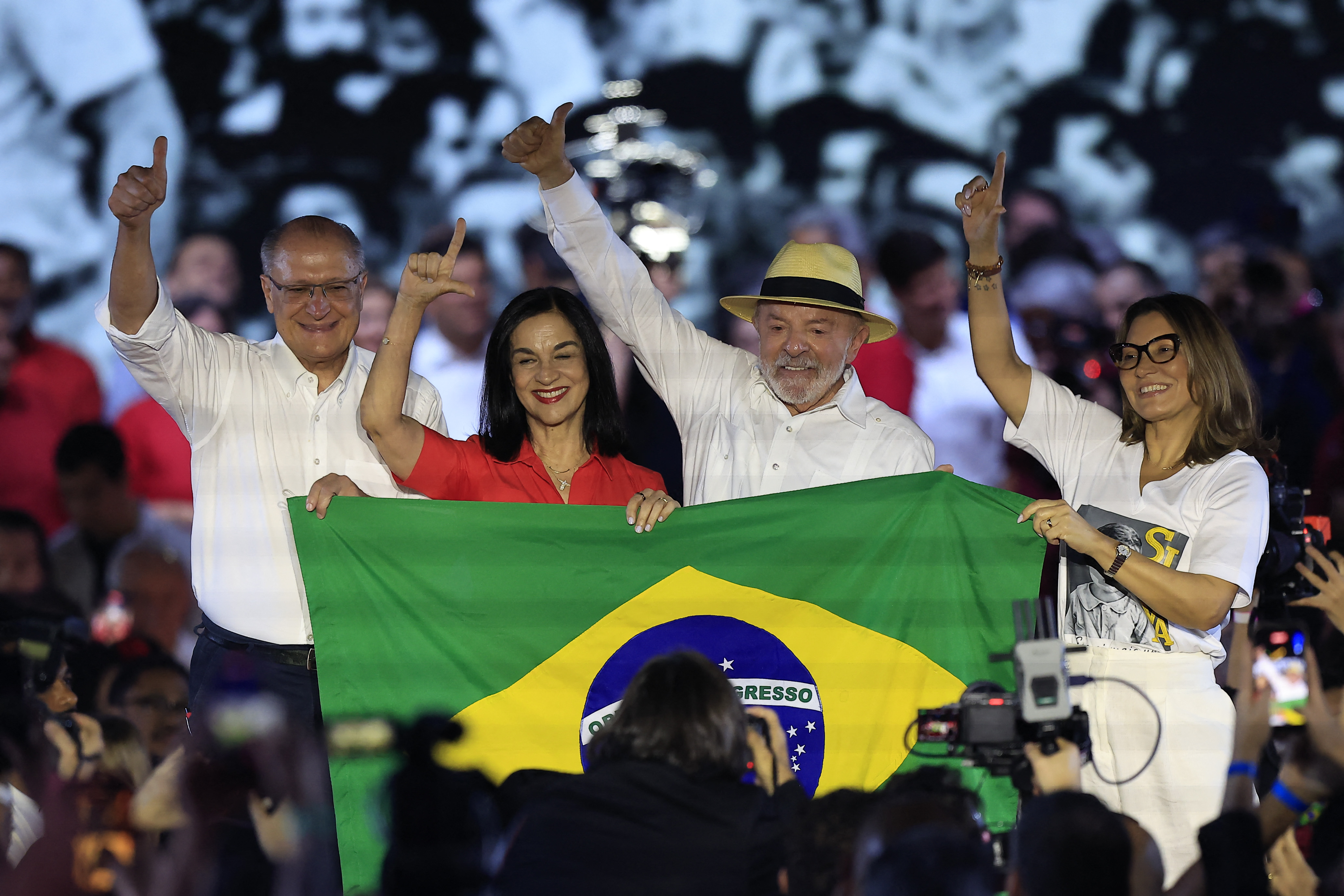 (L to R) Brazil's Vice-President Geraldo Alckmin, Brazil's second lady Maria Lucia "Lu" Alckmin, Brazilian President Luiz Inacio Lula da Silva and First Lady Rosangela "Janja" da Silva hold a Brazilian flag and gesture from a stage during the Workers' Party (PT) national convention in Sao Paulo, Brazil, on August 2, 2026, where Lula formally announces his bid for re-election. At 80, President Lula on July 2 launches his bid for re-election, casting himself as a defender of Brazil's "sovereignty" as pressure from President Donald Trump's administration casts a shadow over the campaign. (Photo by Miguel SCHINCARIOL / AFP)