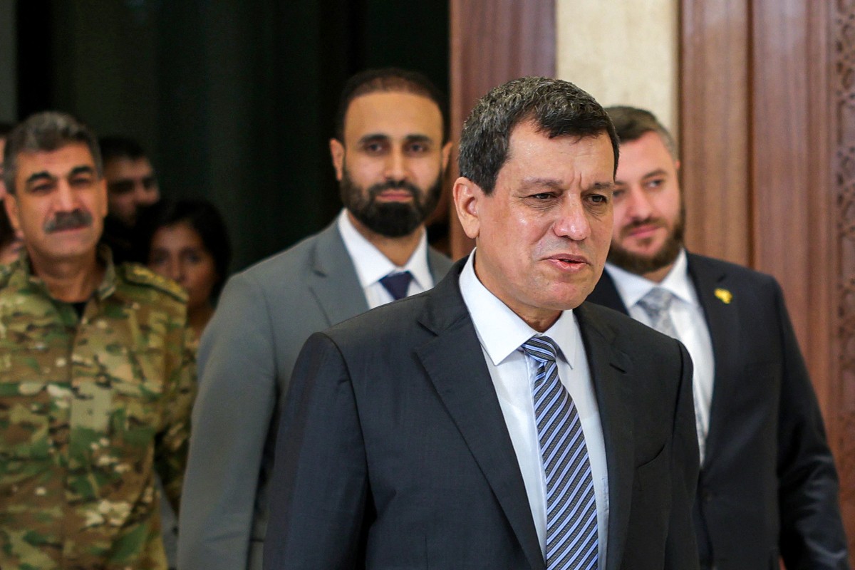 Mazloum Abdi, foreground, leader of the SDF, arrives at the presidential palace in Damascus on August 25, 2026, to announce the armed group’s dissolution