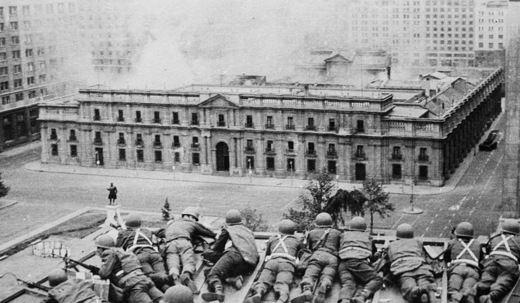 In this September 11, 1973 photo, soldiers supporting the coup led by General Augusto Pinochet take cover as bombs are dropped on the Presidential Palace of La Moneda in Santiago, Chile