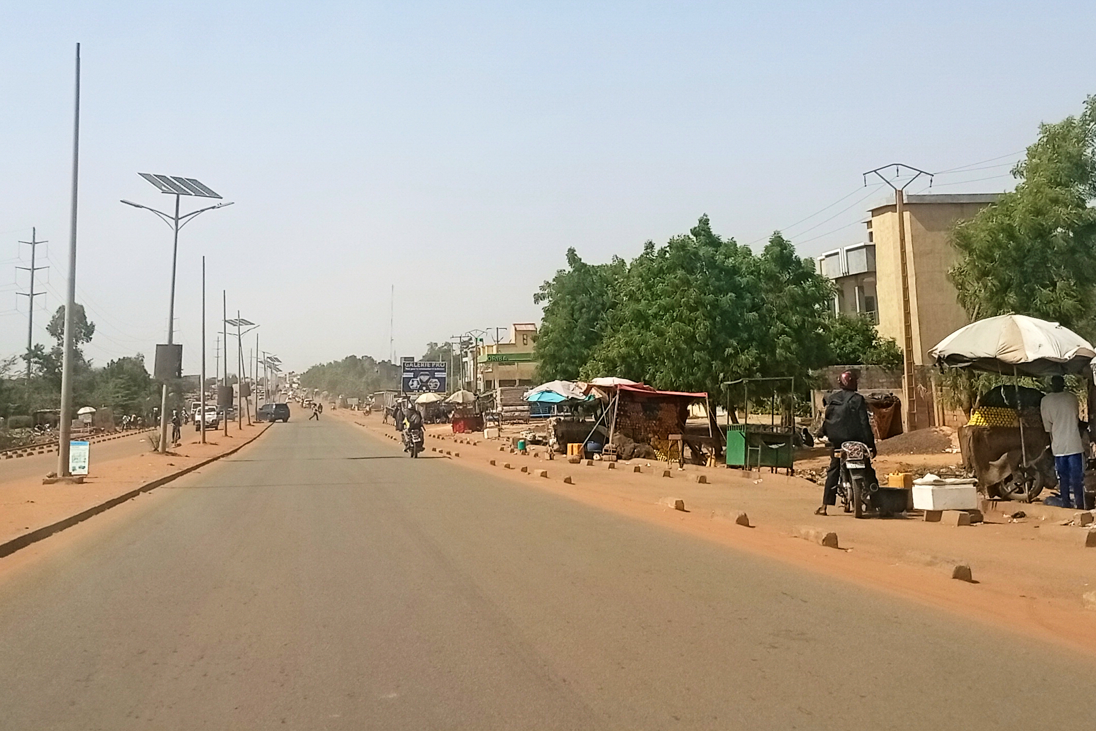 A motorcyclist rides along a street.