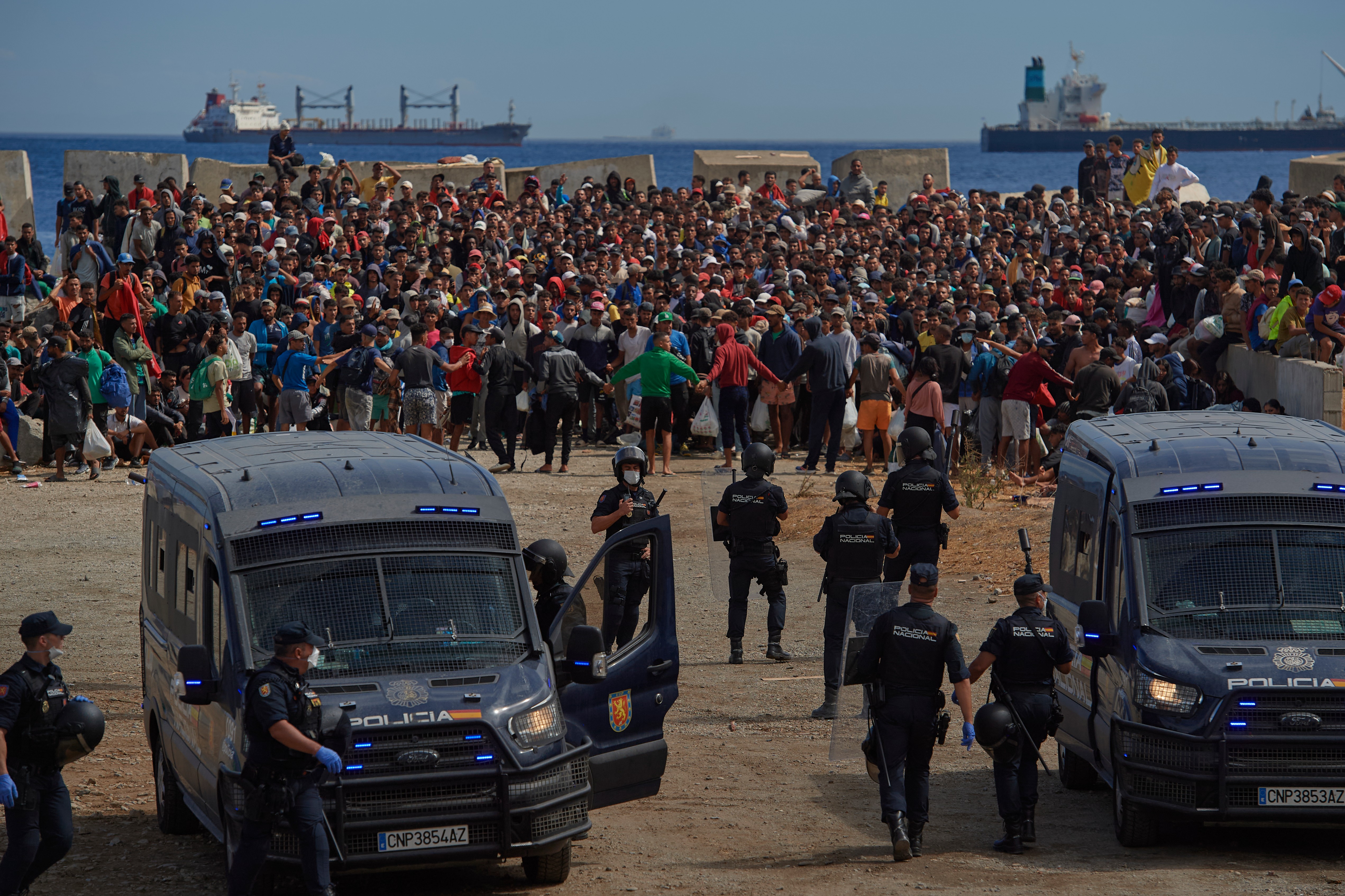 Migrants who crossed from Morocco into Spain return to a beach after being expelled from the area the previous day, as Spanish police escort them in the Spanish enclave of Ceuta, August 21, 2026 [Antonio Sempere/AP]