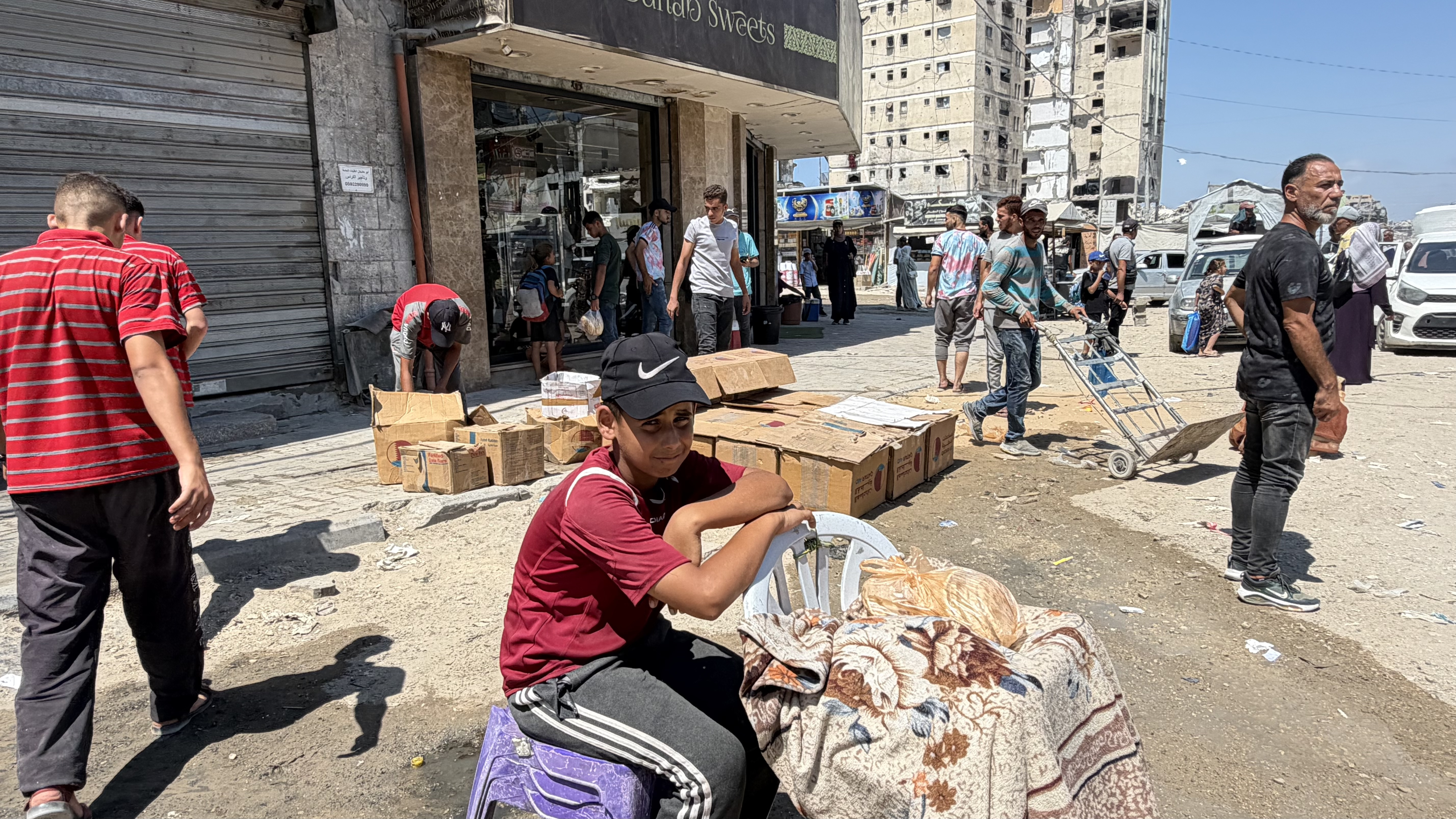 Abdel Hadi Abu Shaaban, centre, uses the internet from a nearby store to receive online bank payments