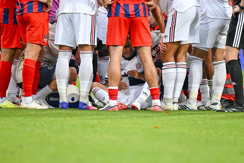 Bayern Munich’s Jamal Musiala, bottom, receives treatment after collapsing