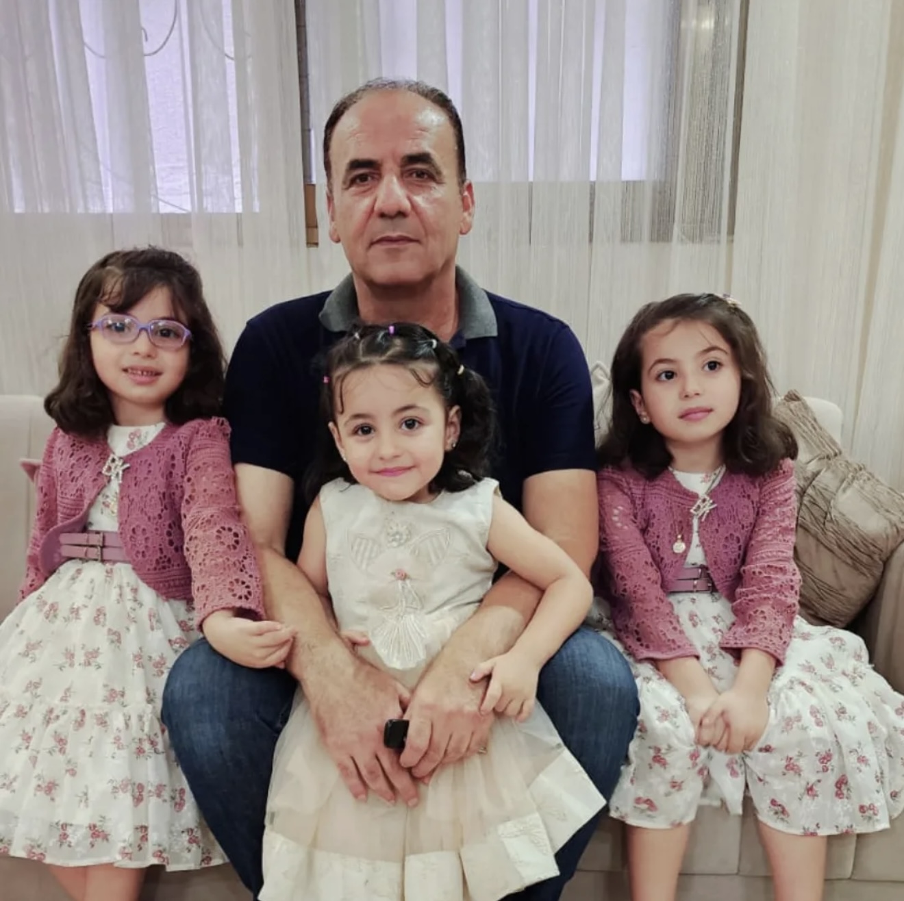 Tala's father with his grandchildren [Eman Abu Zayed/Al Jazeera]