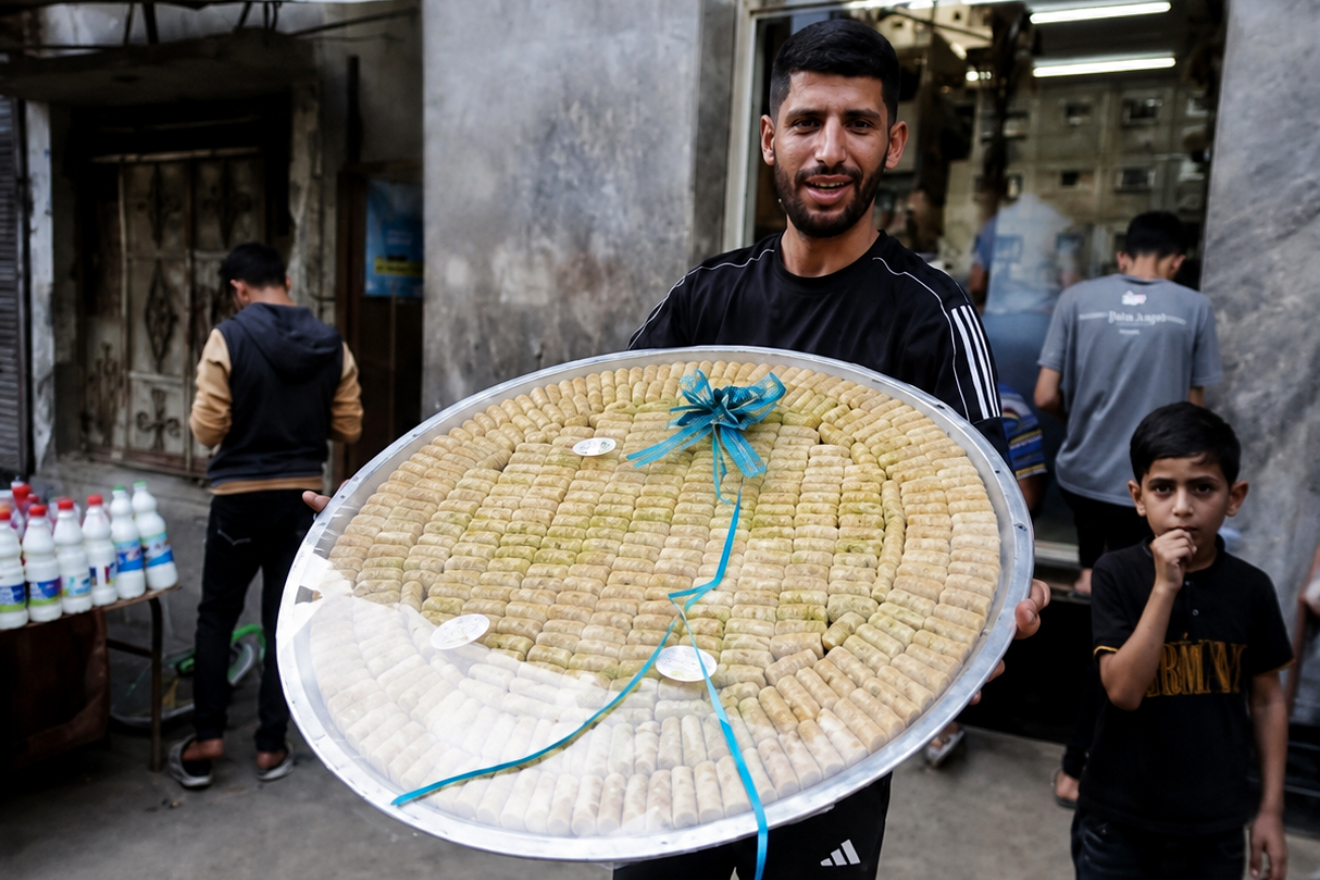 A Palestinian man carries sweets for celebrating exam results in Gaza
