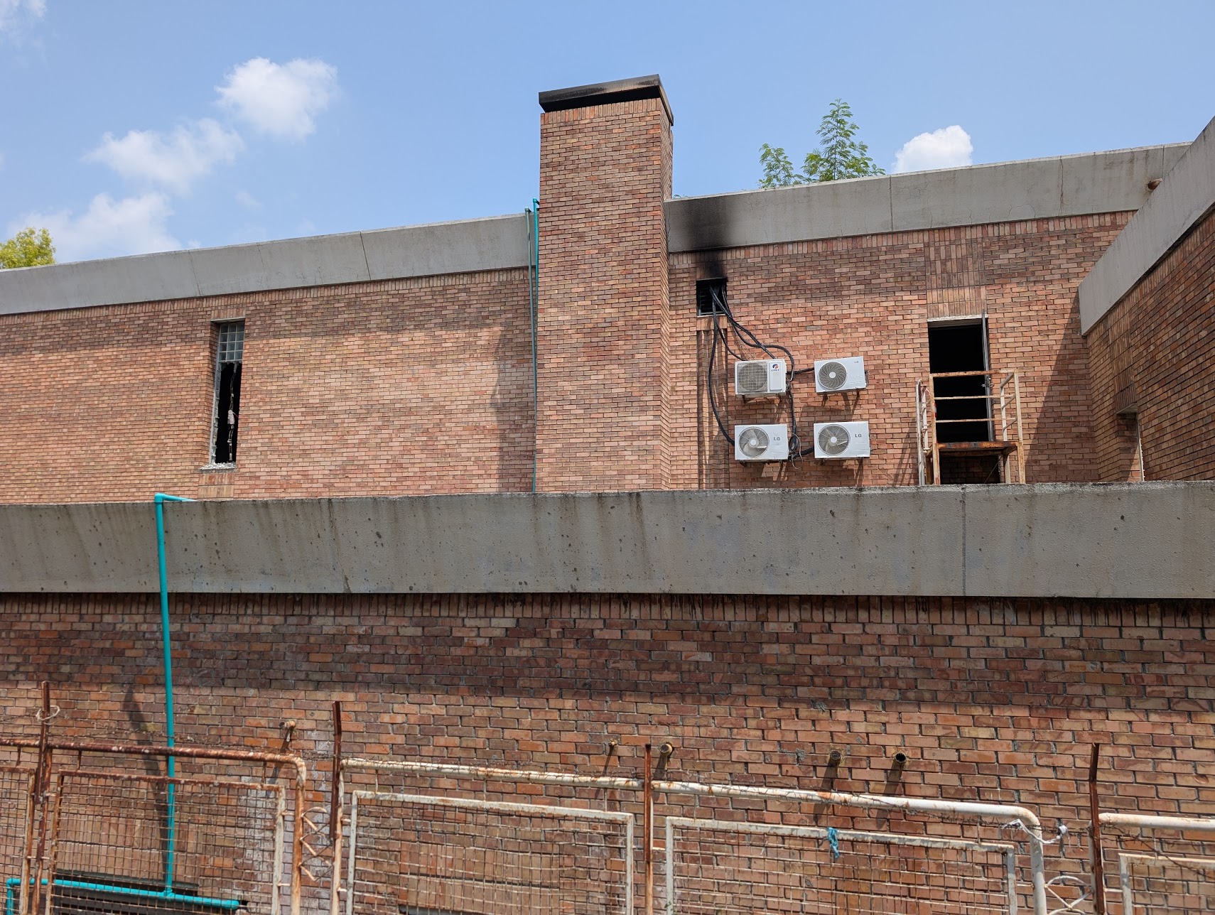 The rear of the ward, where rescue teams worked to reach those trapped. Scorch marks are visible around a burned window and above the external air-conditioning units on the wall