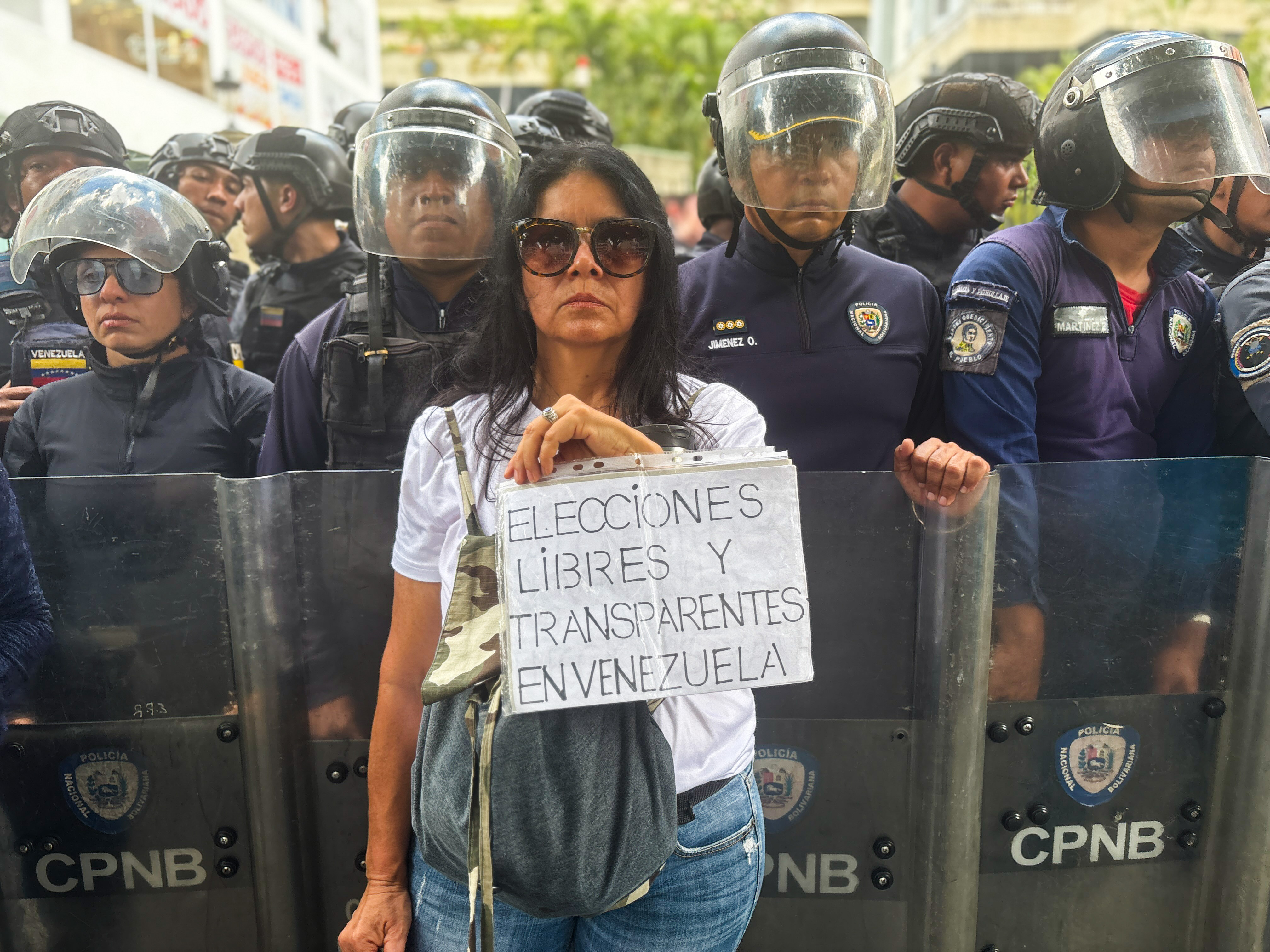 A woman holds a sign that calls for free and transparent election in Venezuela