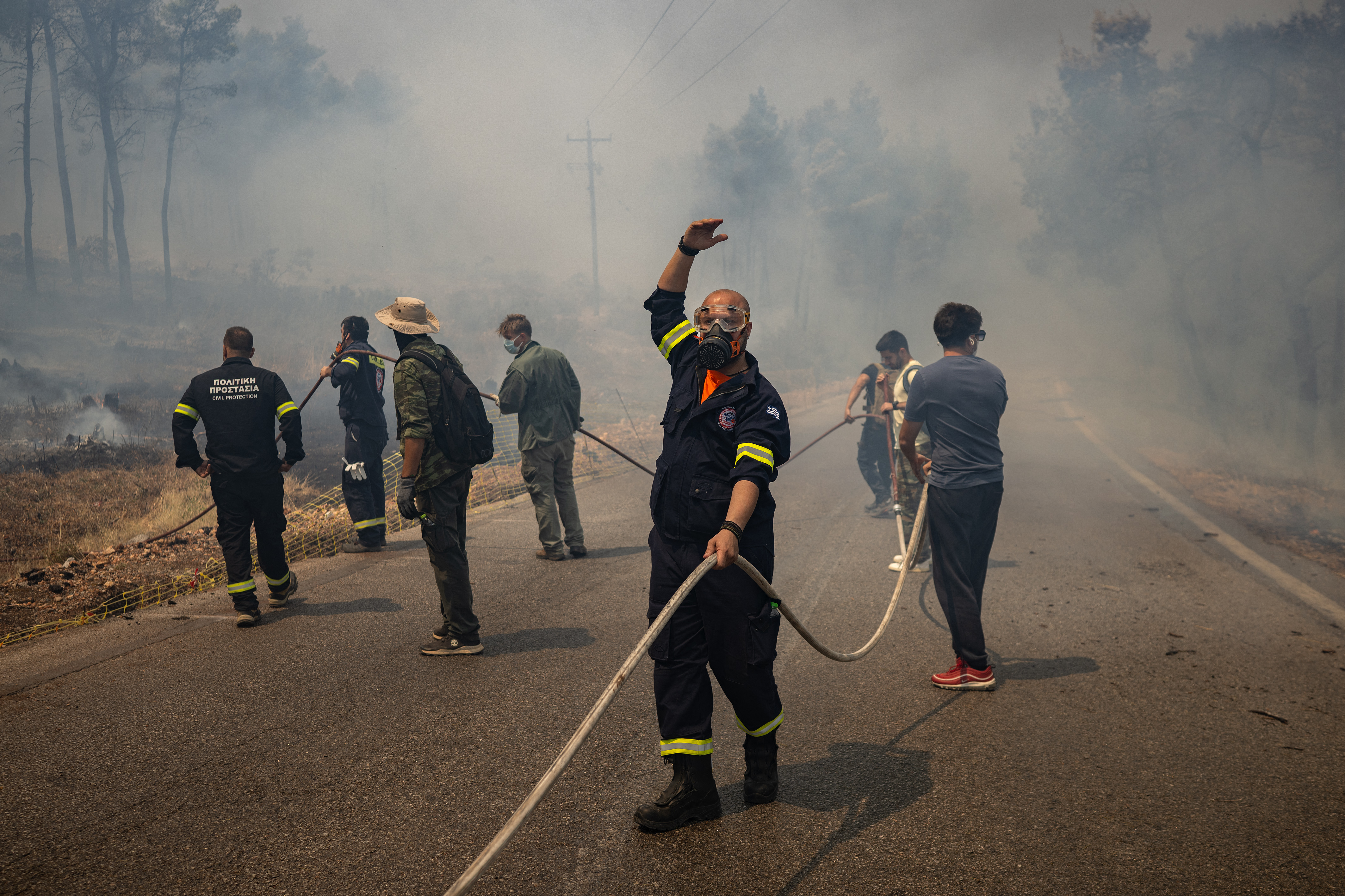 TOPSHOT - Volunteers and Greek firefighters work to extinguish a wildfire near Porto Germeno, some 70 kilometres (45 miles) northwest of Athens in the region of Viotia, on August 2, 2026.