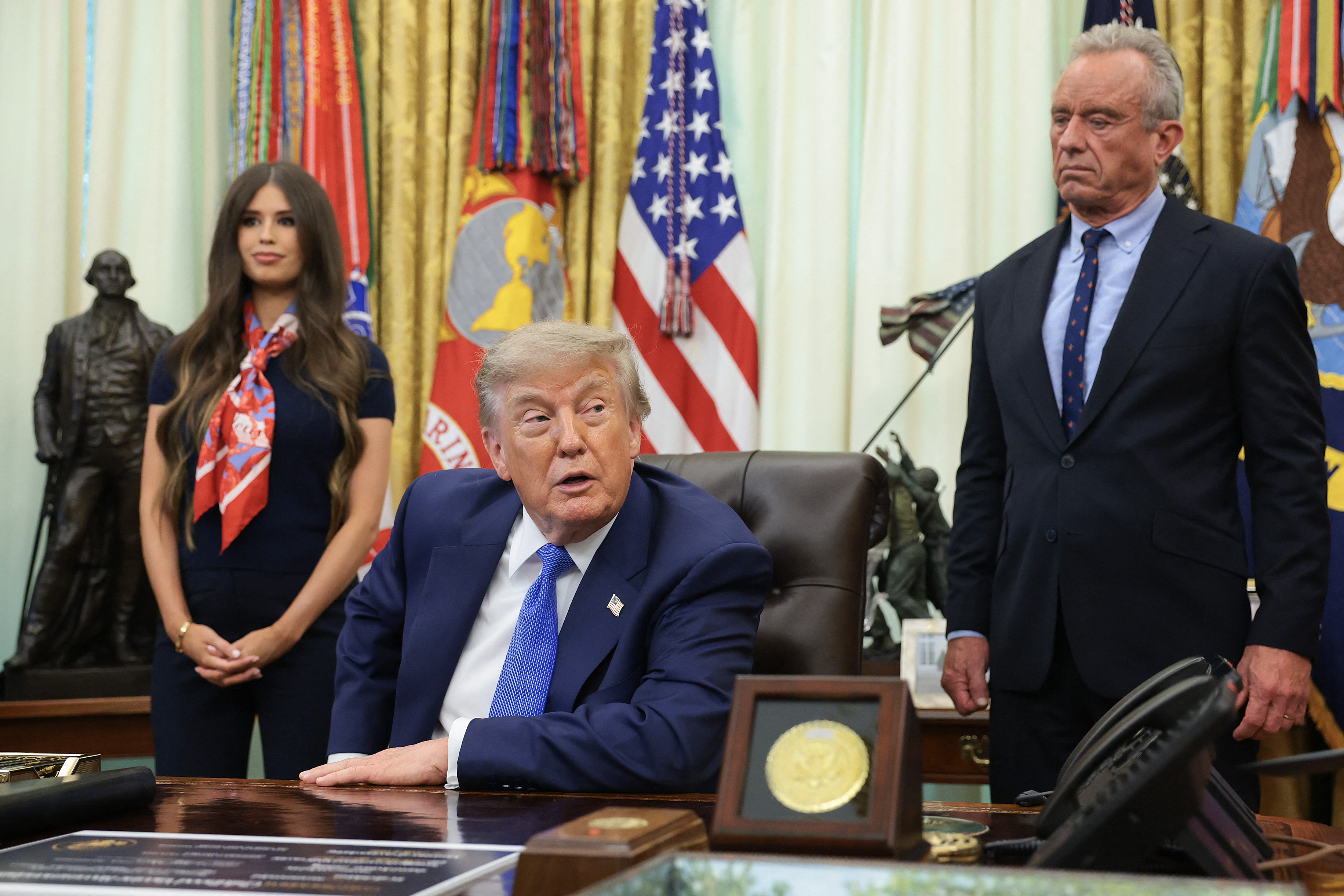 WASHINGTON, DC - AUGUST 10: U.S. President Donald Trump, accompanied by Health and Human Services Secretary Robert F. Kennedy Jr. (R) and Jayme Leagh Franklin with the The Conservateur (L), speaks after signing an executive order calling for childhood vaccine shots to be spaced out into separate visits during an event in the Oval Office of the White House on August 10, 2026 in Washington, DC. During his second term, Trump has urged Health and Human Services Secretary Robert F. Kennedy Jr. to investigate further research on vaccines. Anna Moneymaker/Getty Images/AFP (Photo by Anna Moneymaker / GETTY IMAGES NORTH AMERICA / Getty Images via AFP)
