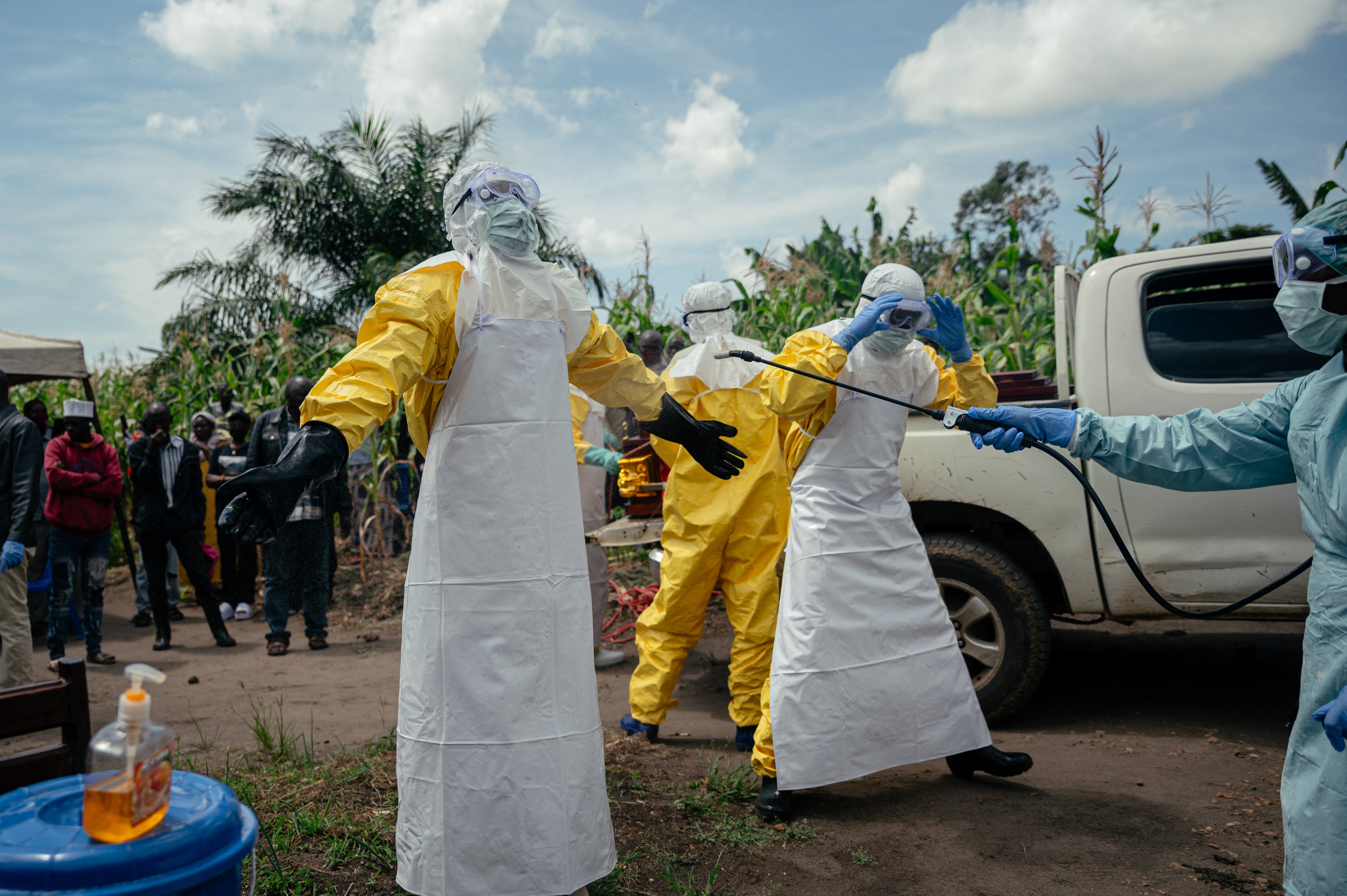 (FILES) Members of a Congolese Red Cross team wearing personal protective equipment disinfect themselves using disinfection sprayers after preparing the coffin of a woman suspected of having died from Ebola virus disease ahead of her safe burial at her home in Bunia on June 7, 2026.