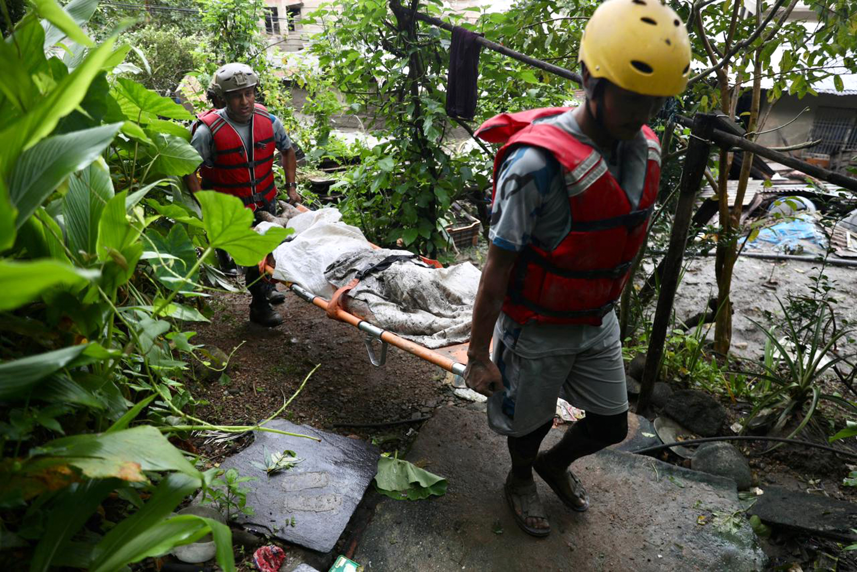 Rescue personnel carry the body of a victim who died after flash floods near Devighat, Bidur Municipality in Nepal's Nuwakot district on August 27, 2026.