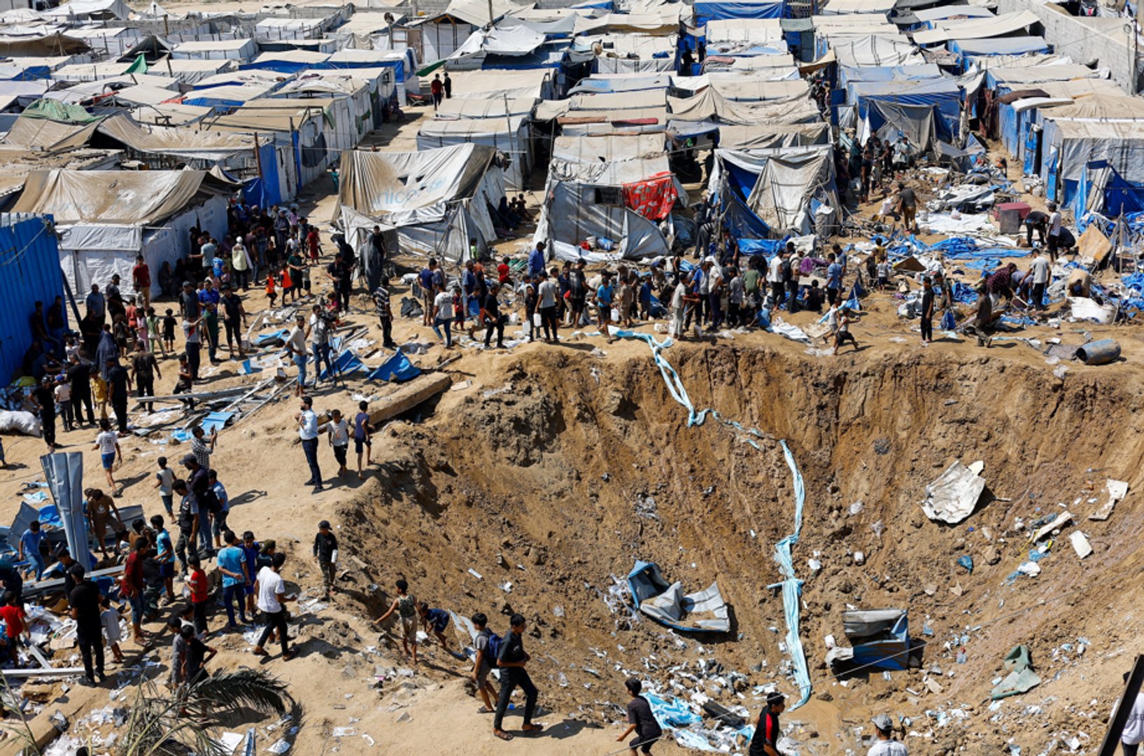 Palestinians inspect the site of an overnight Israeli strike on a medicine warehouse beside tents for displaced people in Deir al-Balah, central Gaza, August 1, 2026. REUTERS/Mahmoud Issa