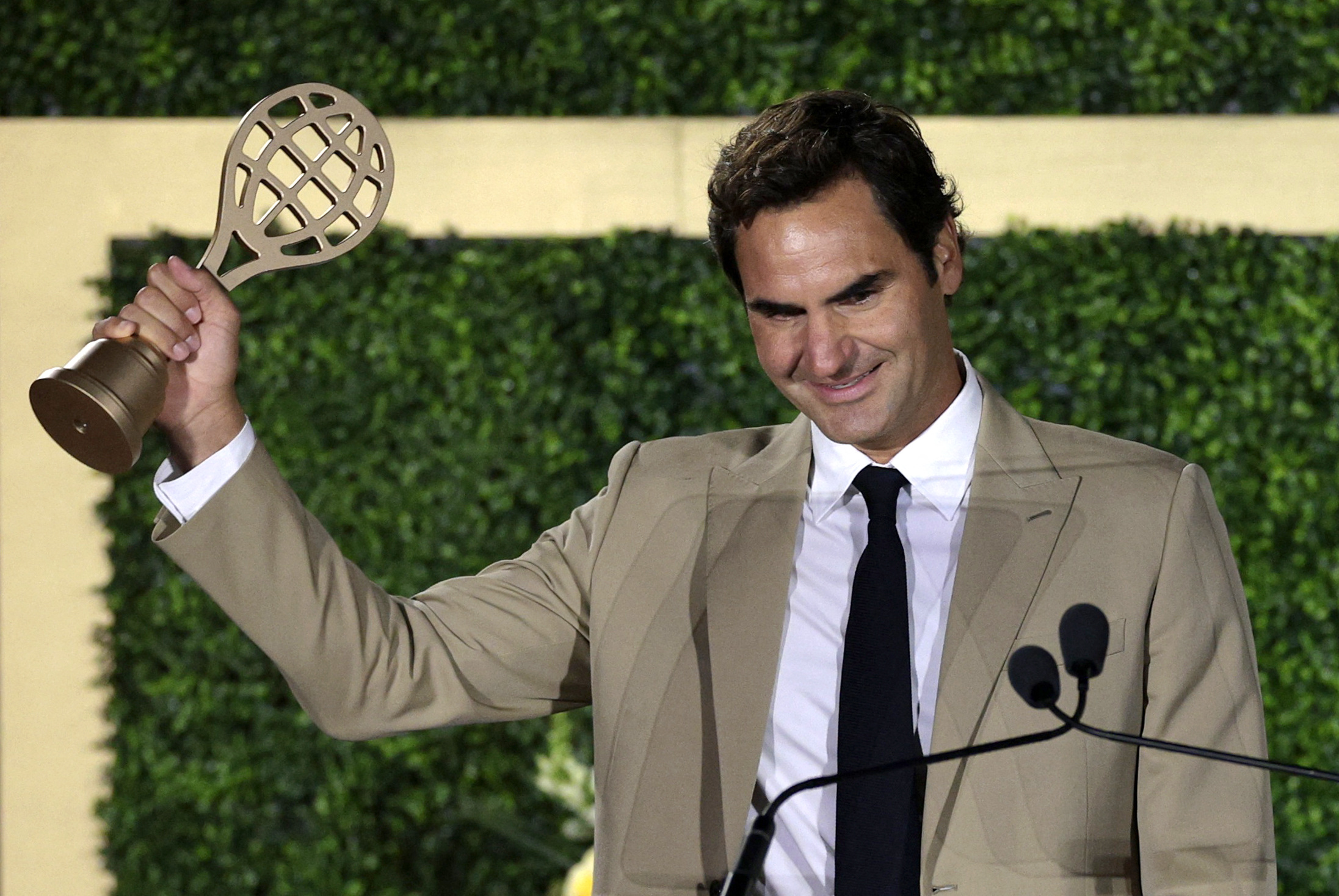 Roger Federer acknowledges from the stage after being inducted into the International Tennis Hall of Fame