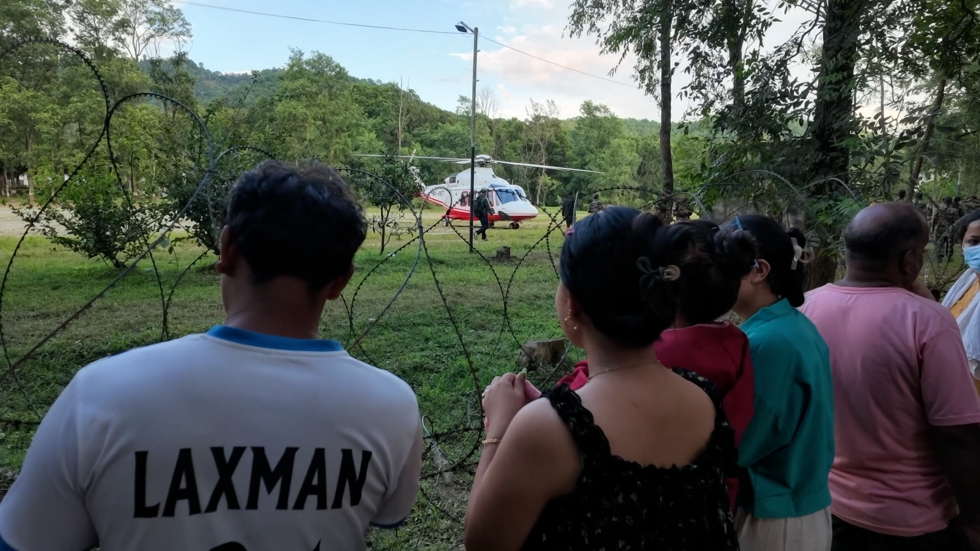 Families of missing people watch as as a rescue helicopter touches down
