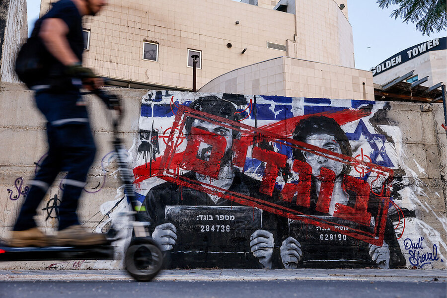 A man rides a scooter as he passes graffiti depicting Yuval Abraham and Rachel Szor, the directors of the documentary film "NAZA," and the word "traitors" in Hebrew, on a wall in Ashdod, southern Israel, Sept. 15, 2026 [Amir Cohen/Reuters]