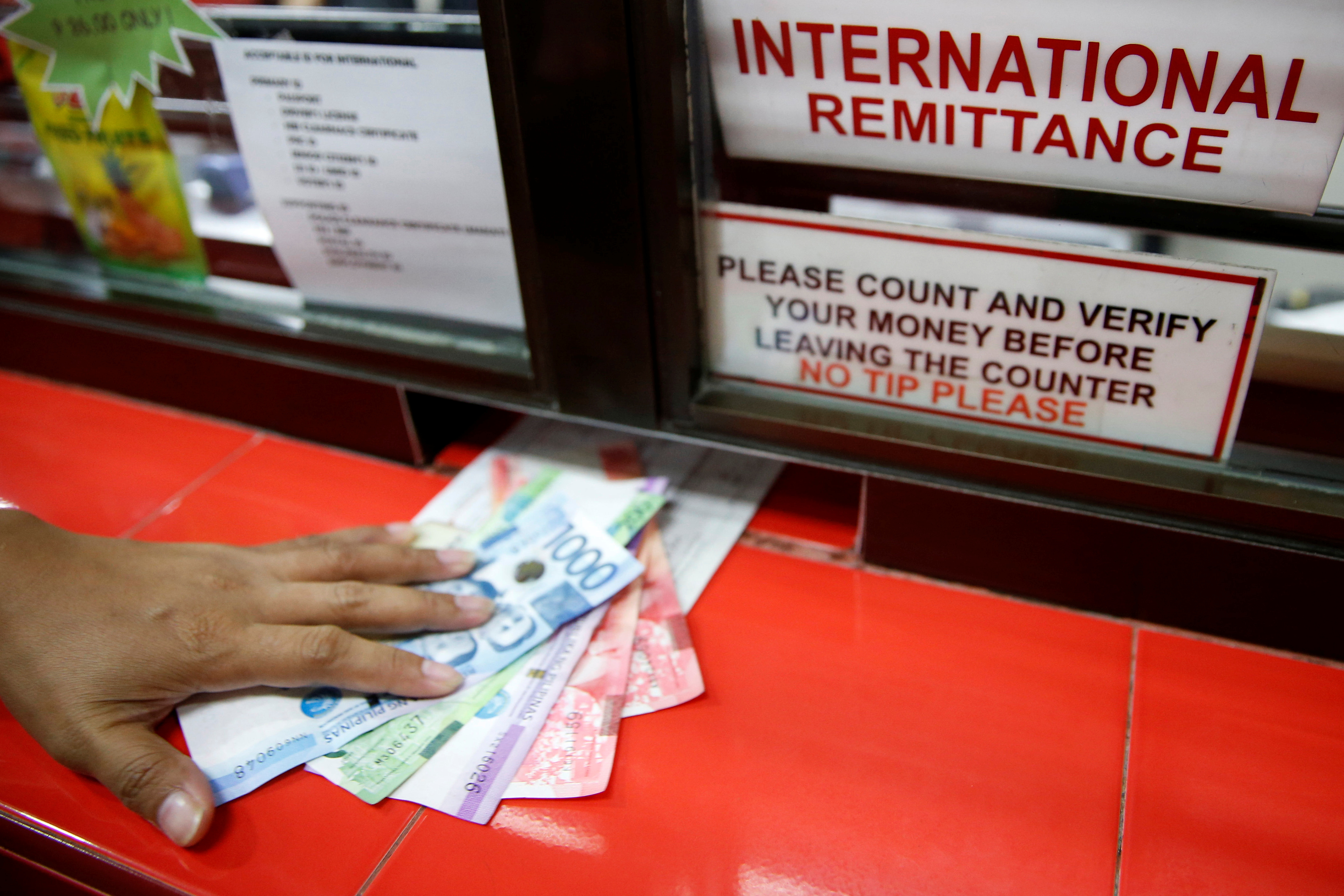 Philippine peso notes are seen on a counter.