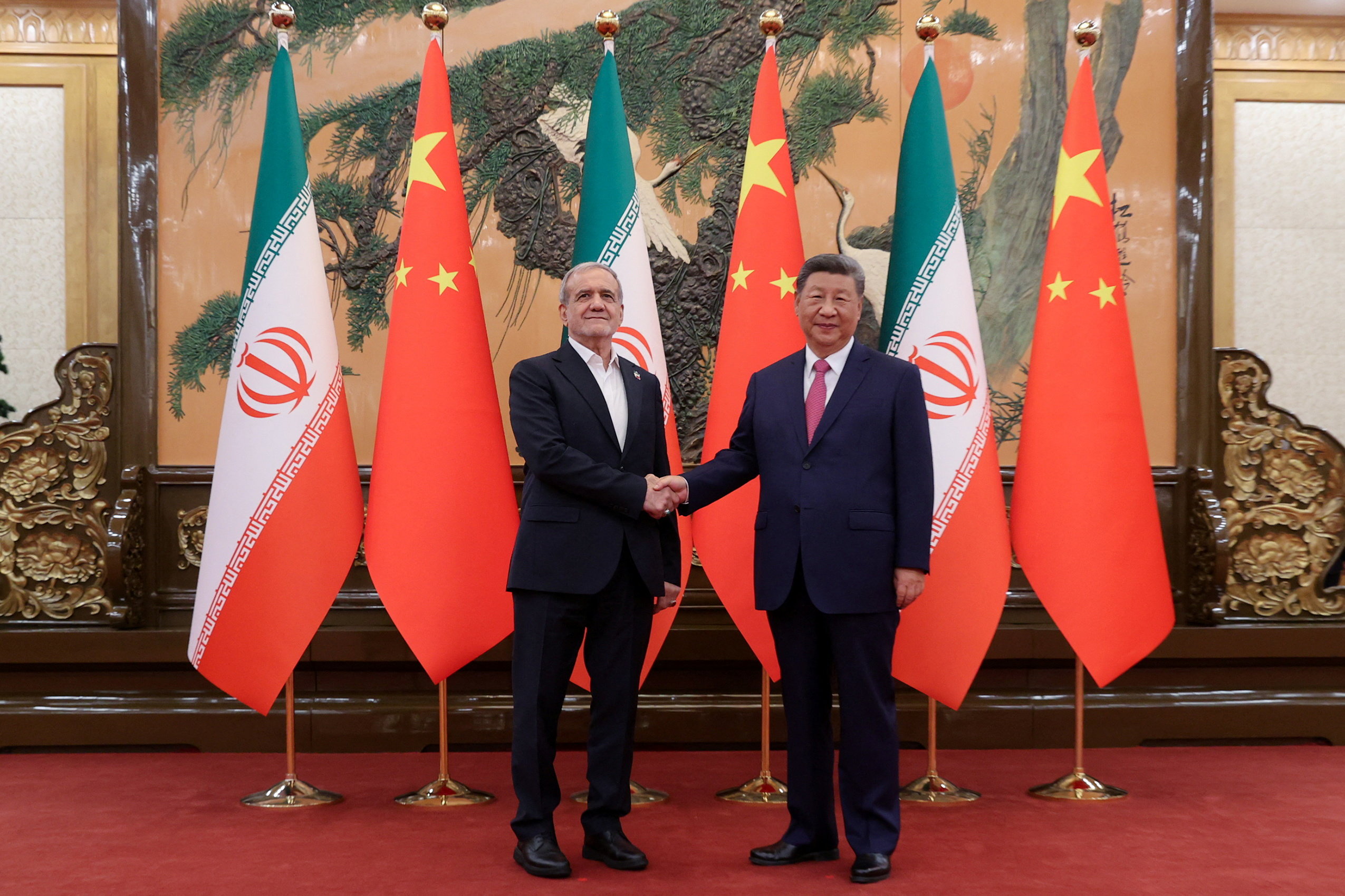 Iranian President Masoud Pezeshkian and Chinese President Xi Jinping shake hands as they meet in Beijing, China, on September 2, 2025