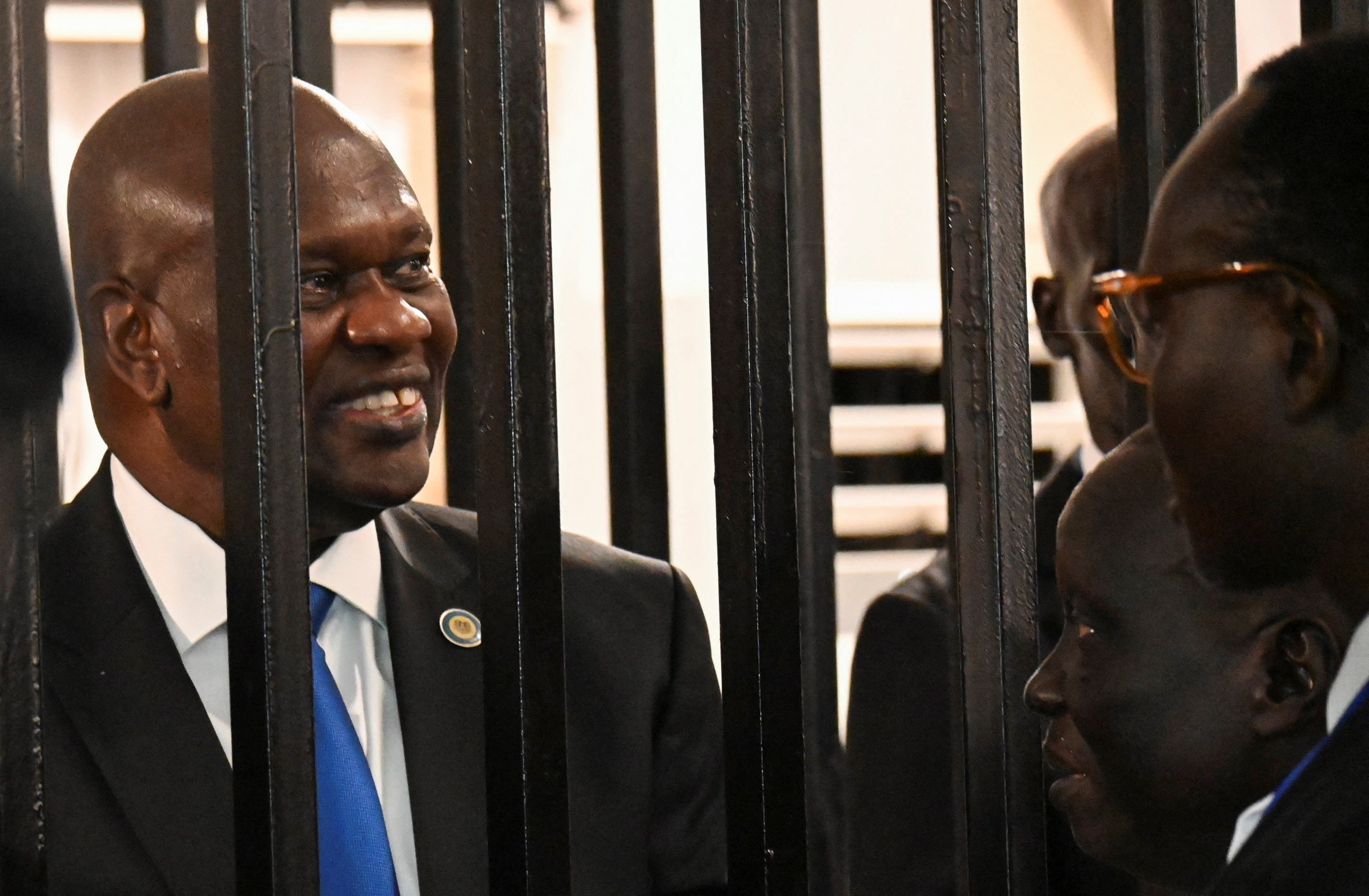 South Sudan’s suspended First Vice President Riek Machar stands inside a steel caged dock as he talks to his legal counsel before his trial on charges including treason and crimes against humanity, at the Freedom Hall in Juba, South Sudan, September 22, 2025. REUTERS/Stringer