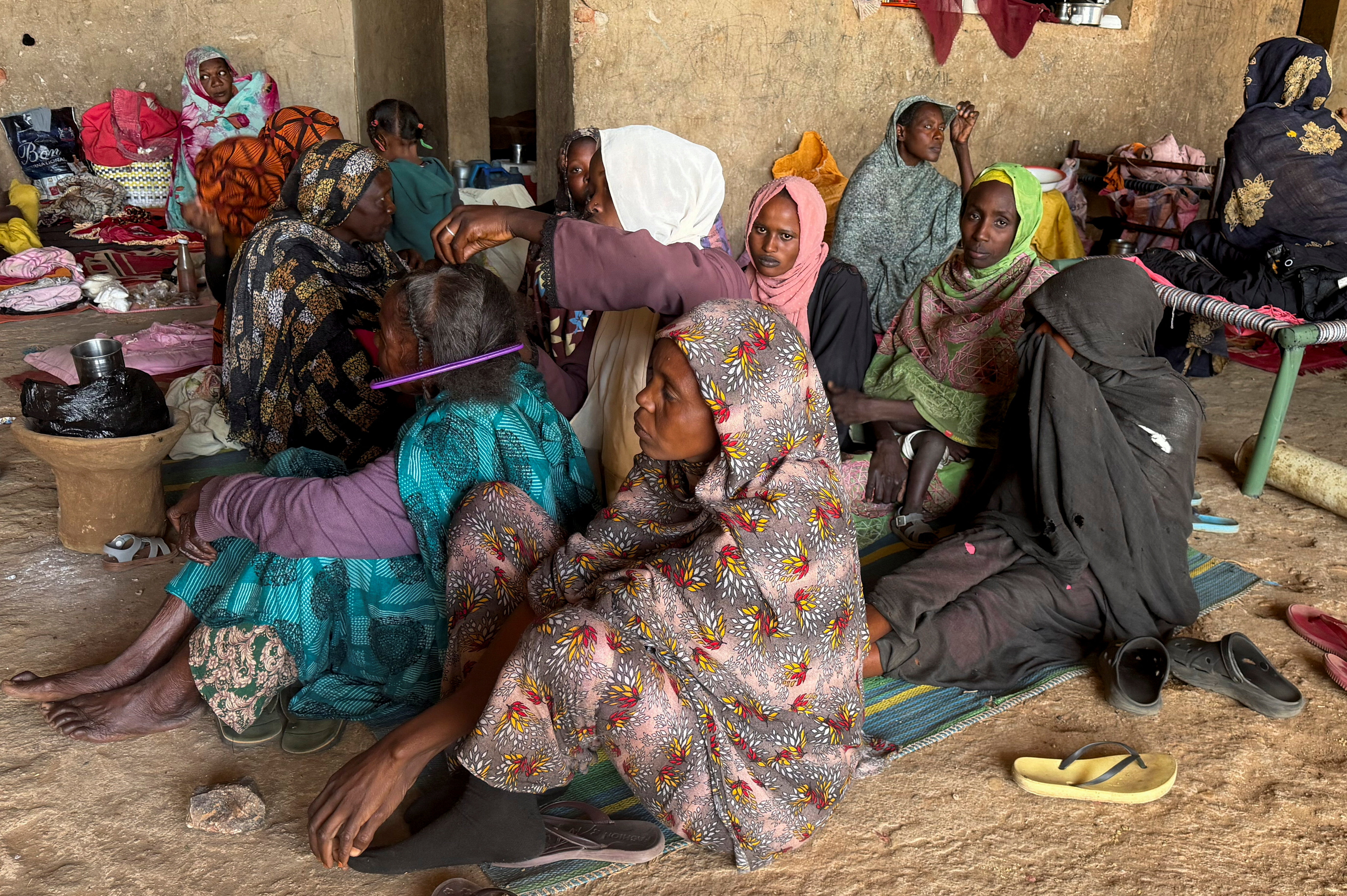 A displaced woman from Dalanj braids her grandmother's hair at a displacement registration center in El Obeid, North Kordofan State, Sudan, January 15, 2026. REUTERS/El Tayeb Siddig