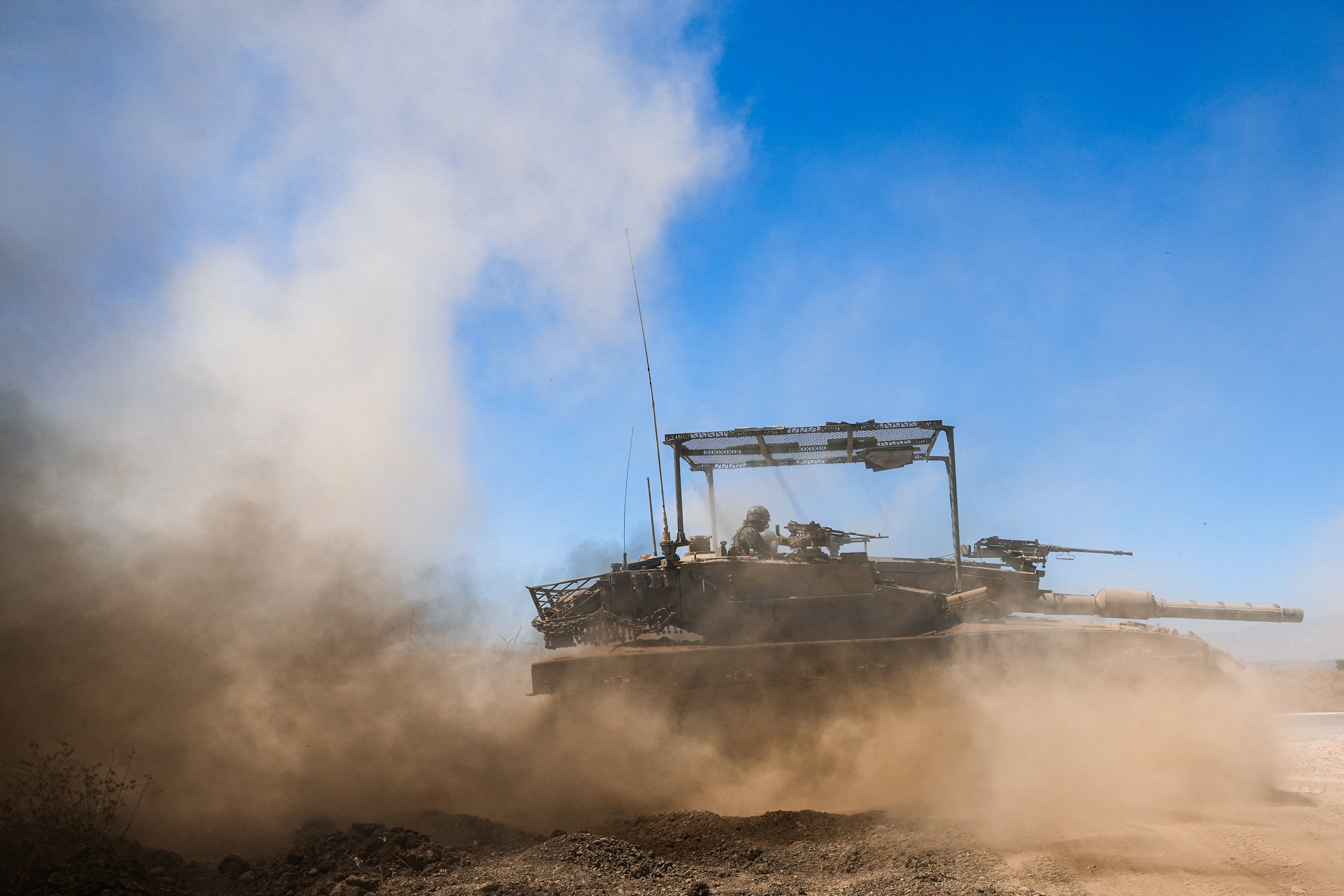 An Israeli tank drives along the ceasefire line between the Israeli-occupied Golan Heights and Syria