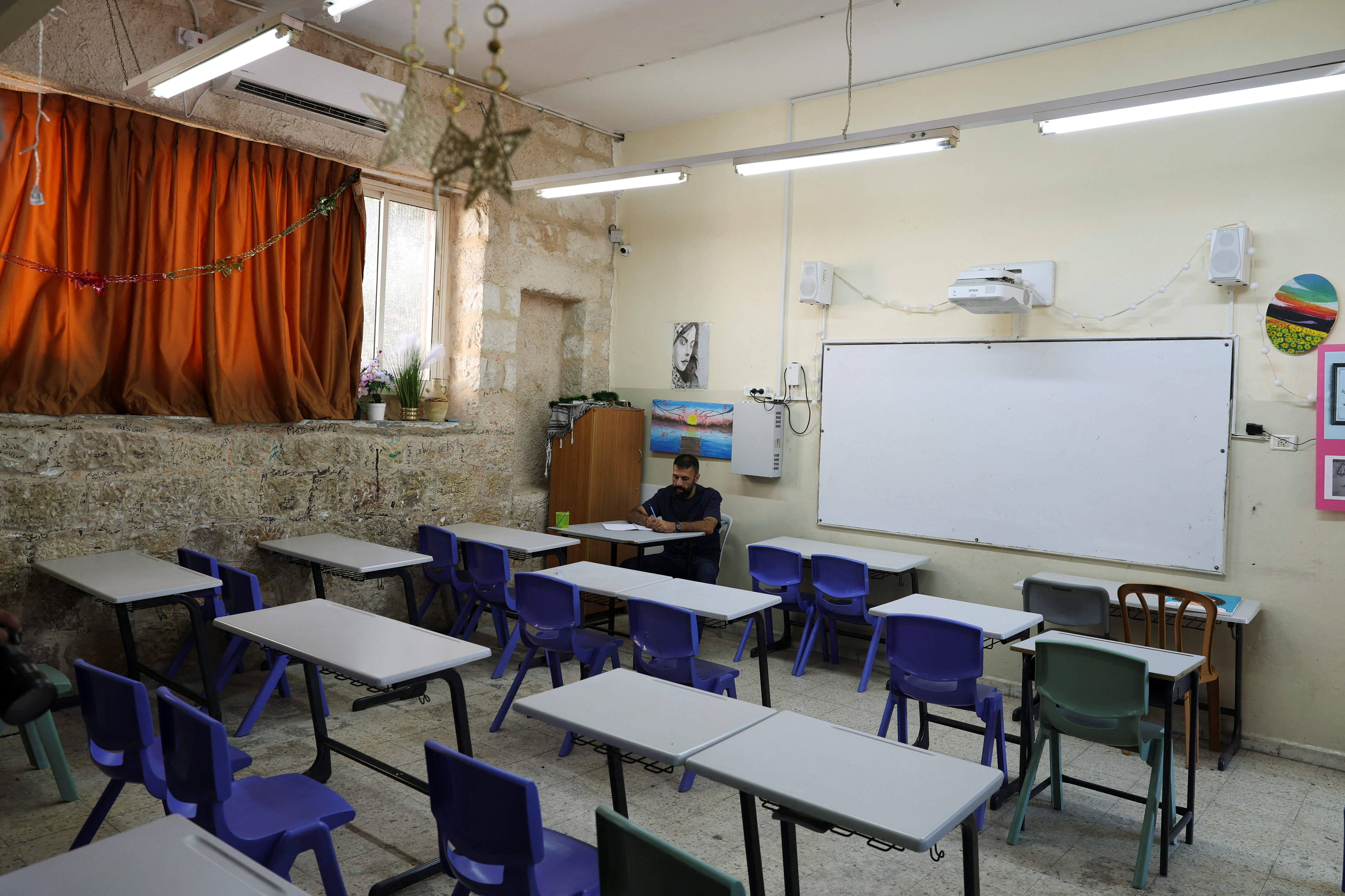 A Palestinian teacher sits in an empty classroom at St. George's school after Palestinian schools declared a strike in protest to Israel refusing to renew the entry permits of teachers from the Israeli-occupied West Bank, in Jerusalem, September 1, 2026. REUTERS/Ammar Awad
