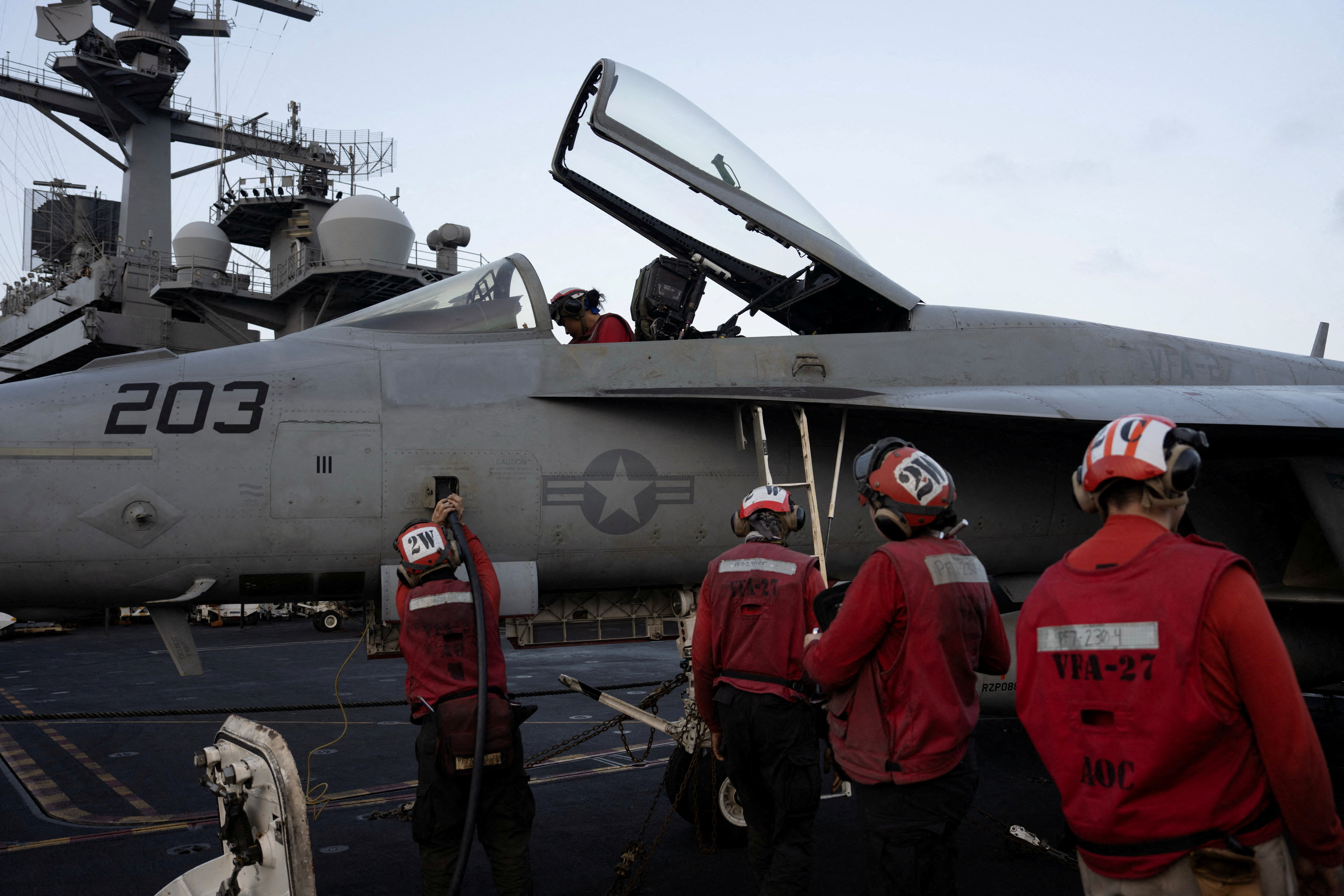 U.S. Navy sailors tend to a fighter jet on the flight deck of the USS George Washington in the Arabian Sea, September 11, 2026. The aircraft carrier, capable of carrying more than 5,000 personnel, is enforcing a U.S. naval blockade against Iran and providing cover for commercial vessels transiting the Strait of Hormuz. REUTERS/Ed Ou