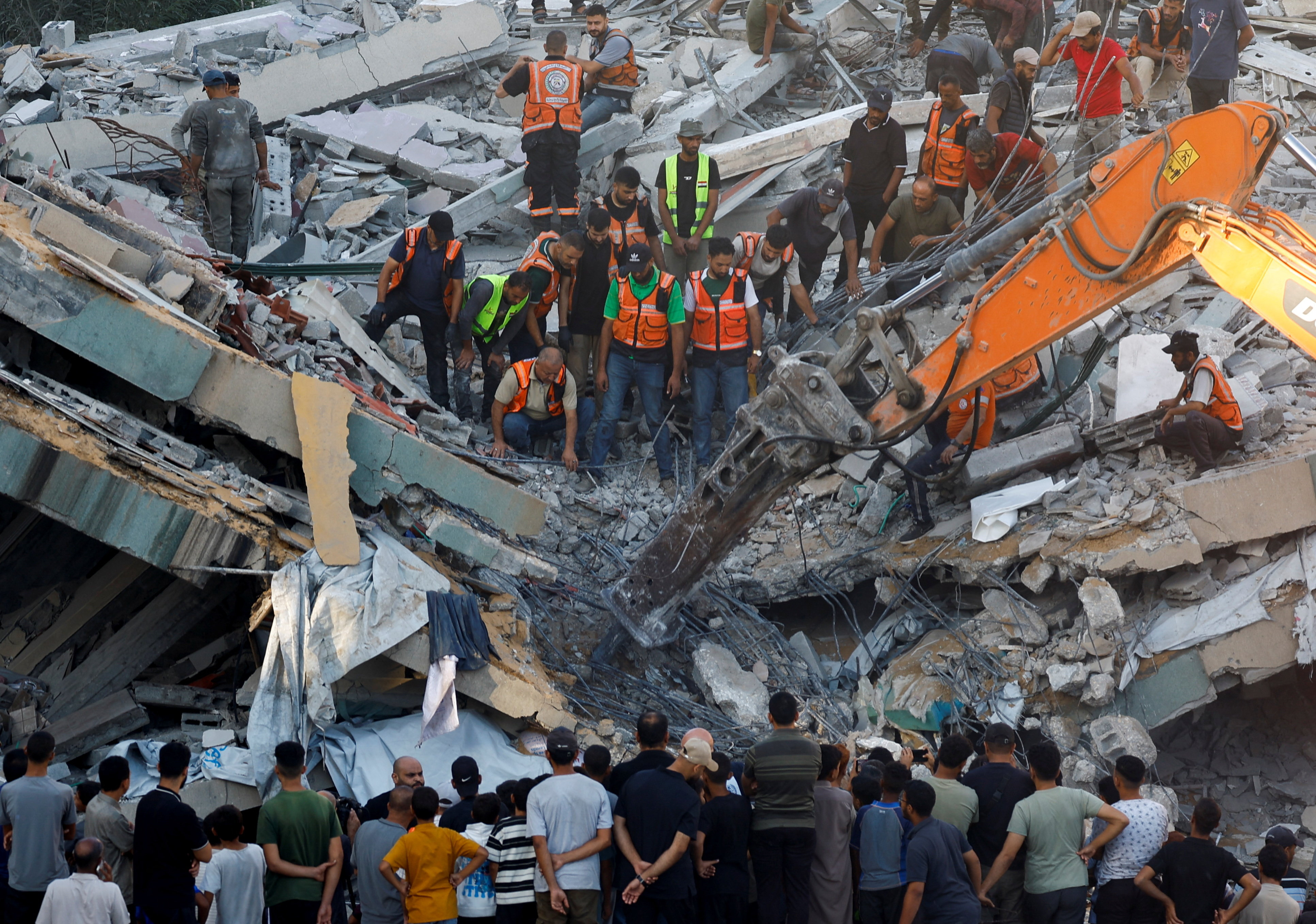 People gather as civil defence workers attempt to rescue those trapped beneath the rubble of a residential building that had been damaged in an earlier Israeli strike during the war and collapsed on Wednesday, in Gaza City, on September 16, 2026