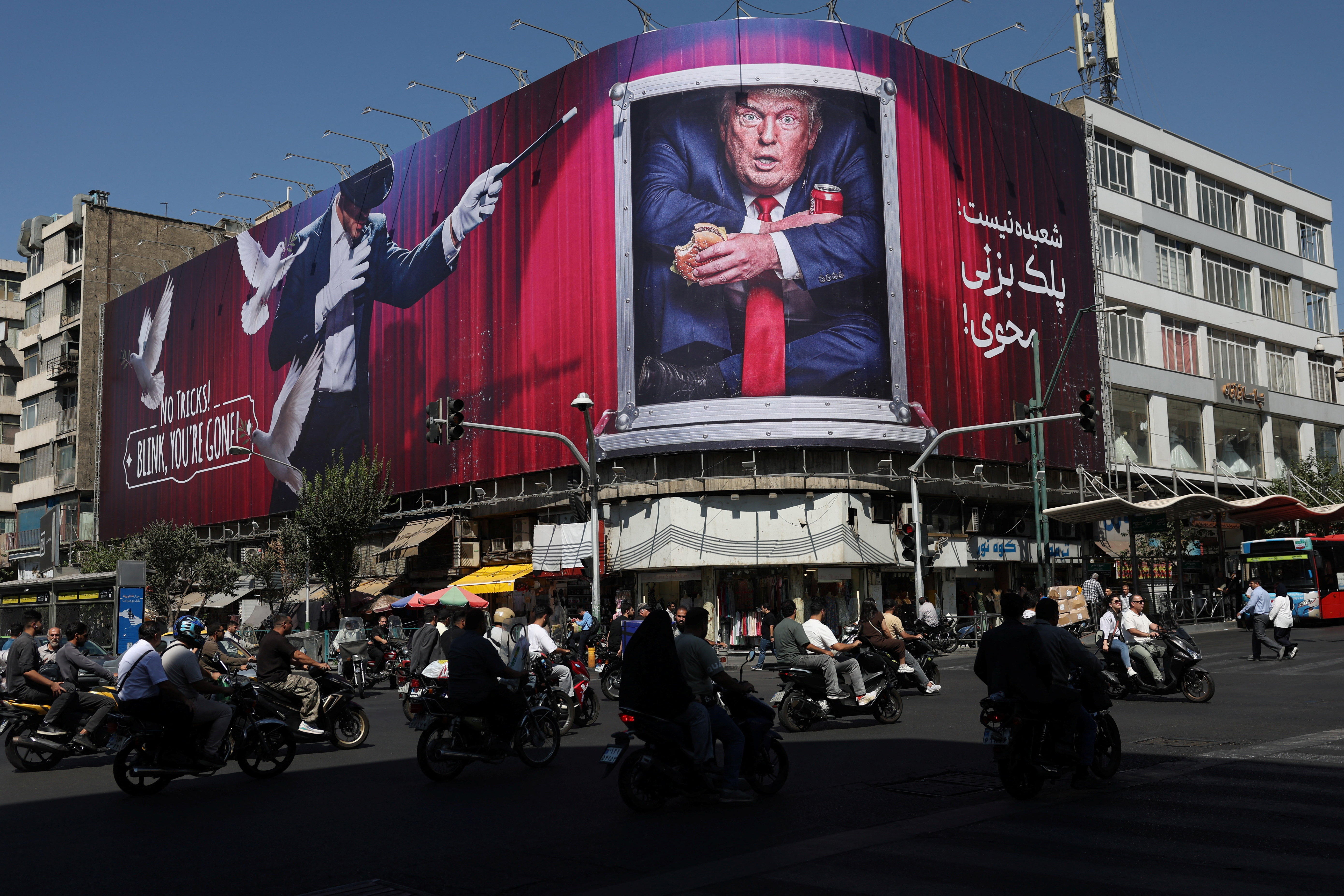 Cars pass a large billboard of Donald Trump on a building in Tehran